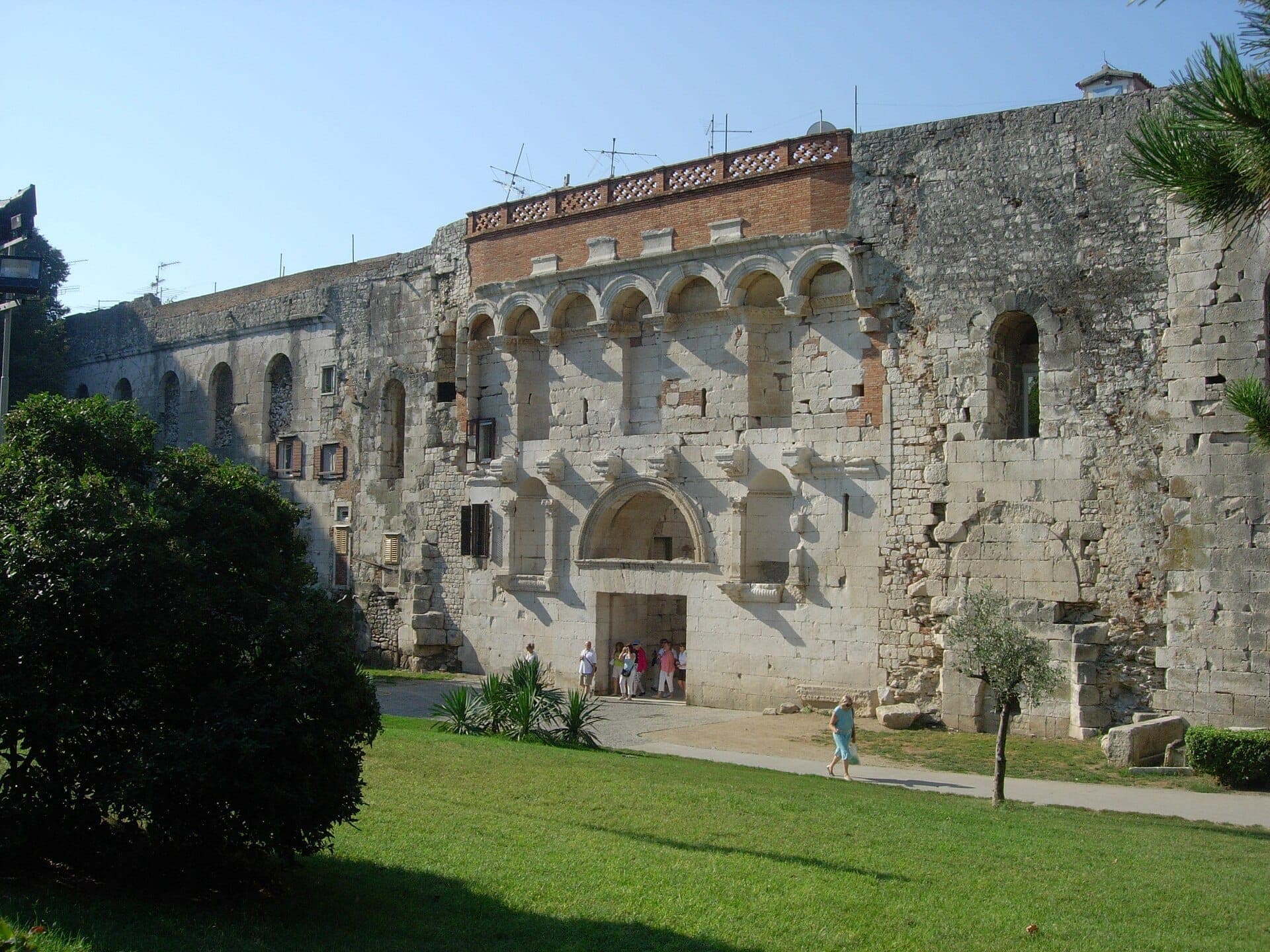 La Porta Aurea del Palazzo di Diocleziano a Split, in Croazia, con i suoi grandi archi in pietra, le antiche mura e i visitatori che entrano al di sotto.