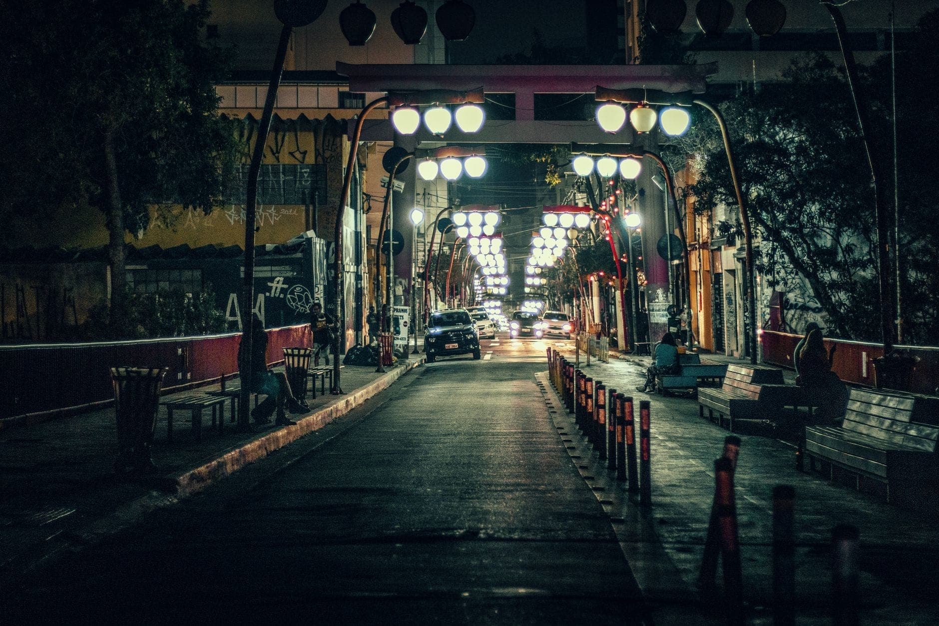 วิวยามค่ำคืนของสะพานคนเดินที่สว่างไสวในย่านบันเทิงยามค่ำคืนของกัวดาลาฮารา พร้อมไฟถนนและผู้คนนั่งอยู่บนม้านั่ง