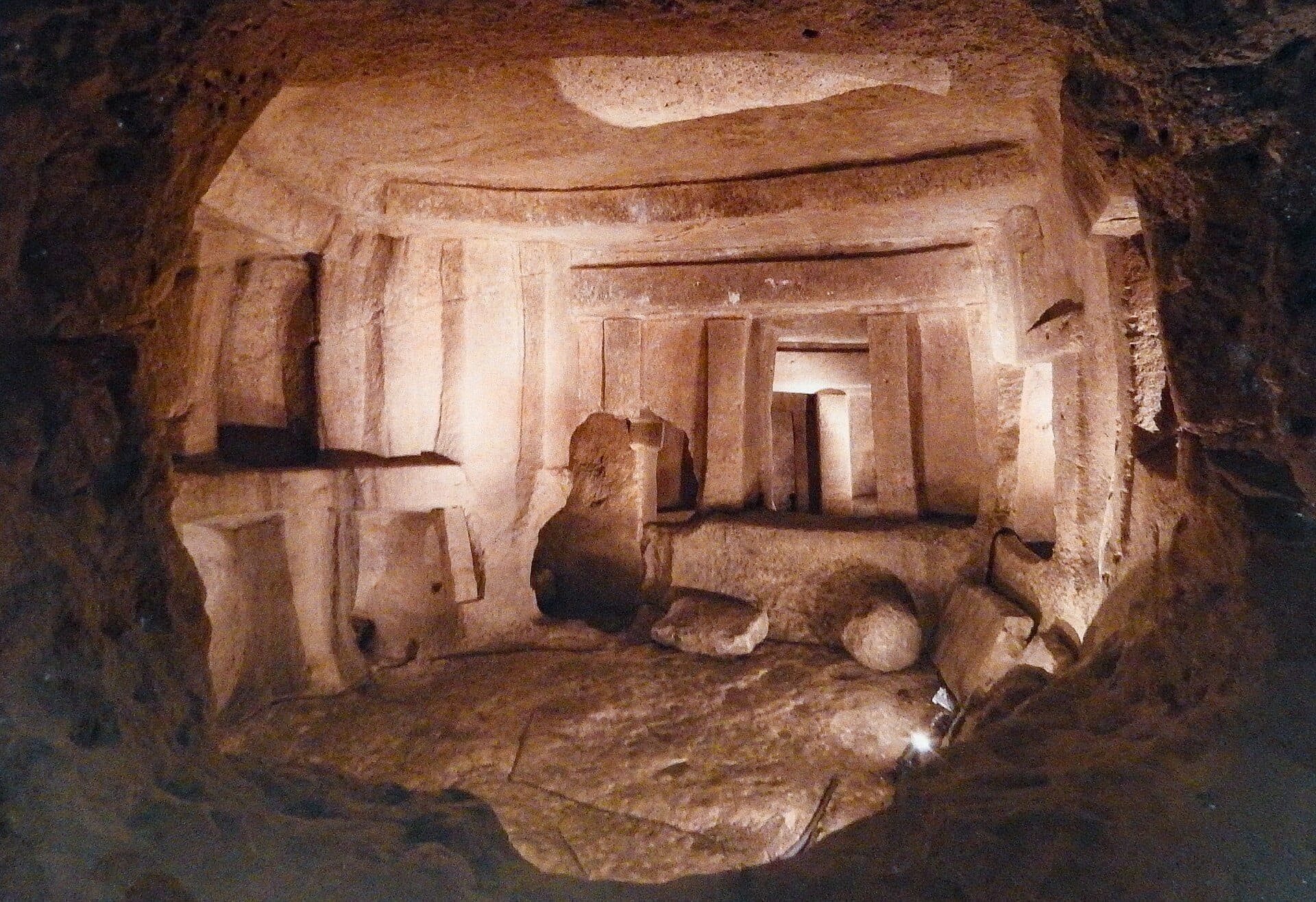 Steinerne Innenkammer der Ħaġar Qim-Tempel mit großen Megalithen, gemeißelten Wänden und sanfter Umgebungsbeleuchtung.