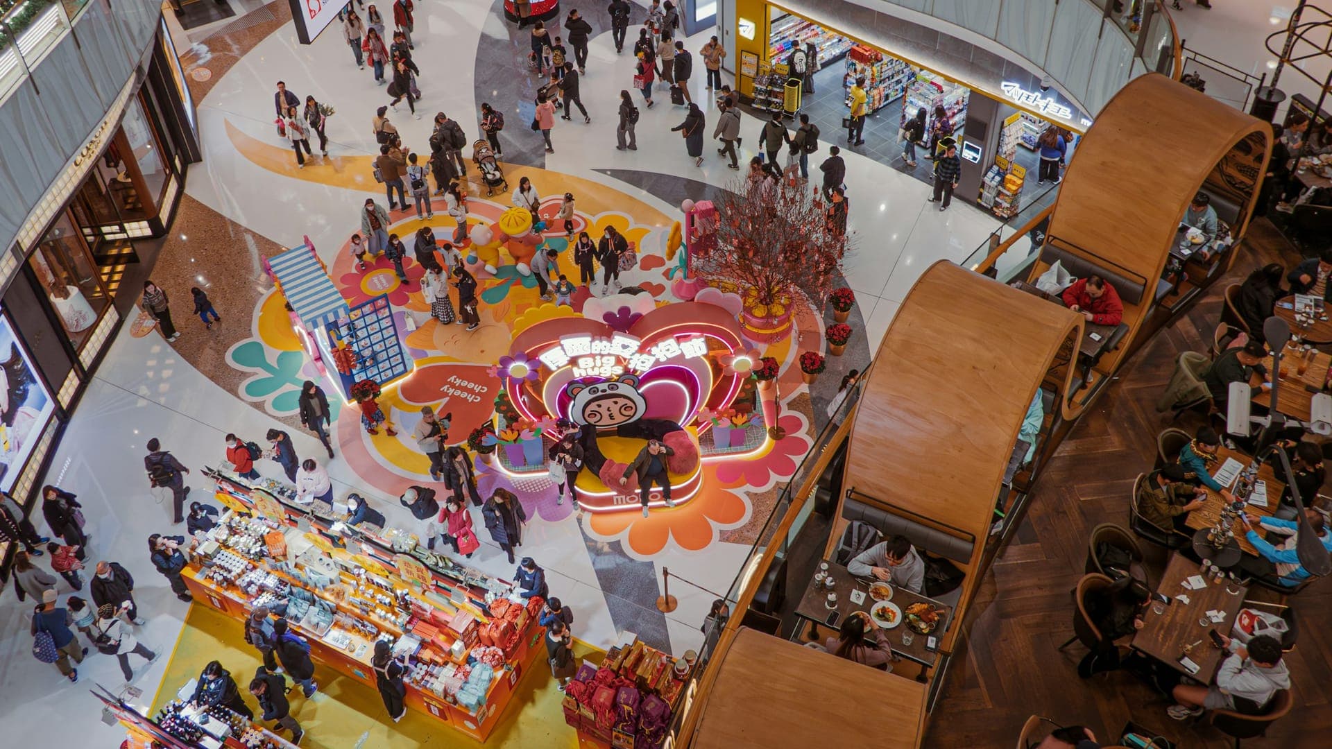 Crowded shopping mall in Hong Kong showing busy walkways, retail shops, and dining areas