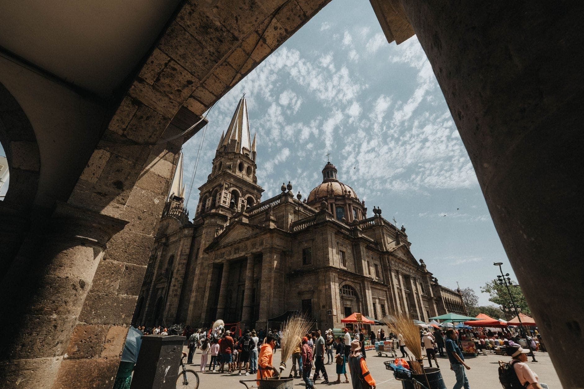 ฝูงชนในเวลากลางวันด้านนอกมหาวิหาร Guadalajara พร้อมพ่อค้าแม่ค้าริมถนนที่คึกคักและครอบครัวต่างๆ