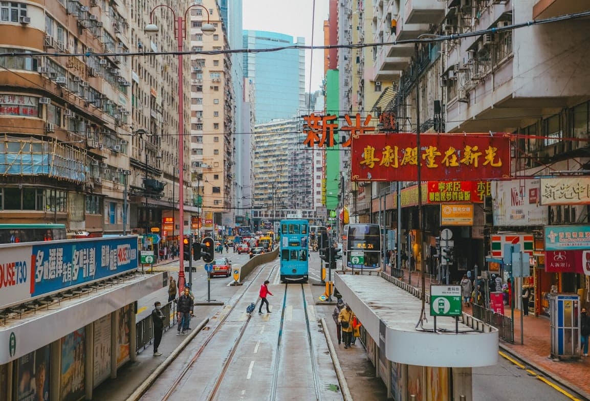 Hong Kong street with double-decker tram, dense apartment buildings, and local shops