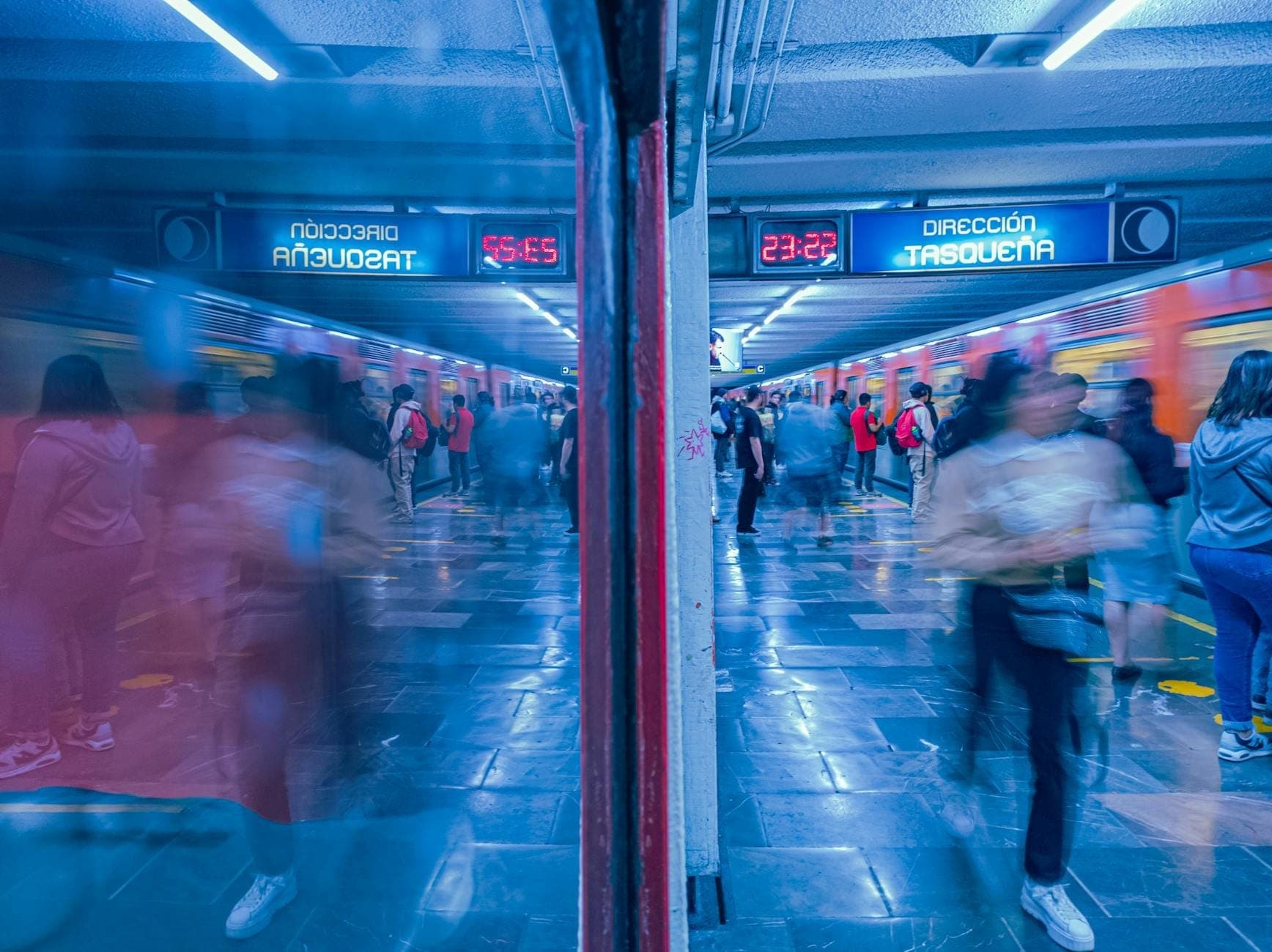 ชานชาลาสถานีรถไฟใต้ดิน Mexico City ที่คึกคักด้วยผู้โดยสารและป้ายดิจิทัล สะท้อนบรรยากาศที่แออัดและการเคลื่อนไหวในช่วงชั่วโมงเร่งด่วน