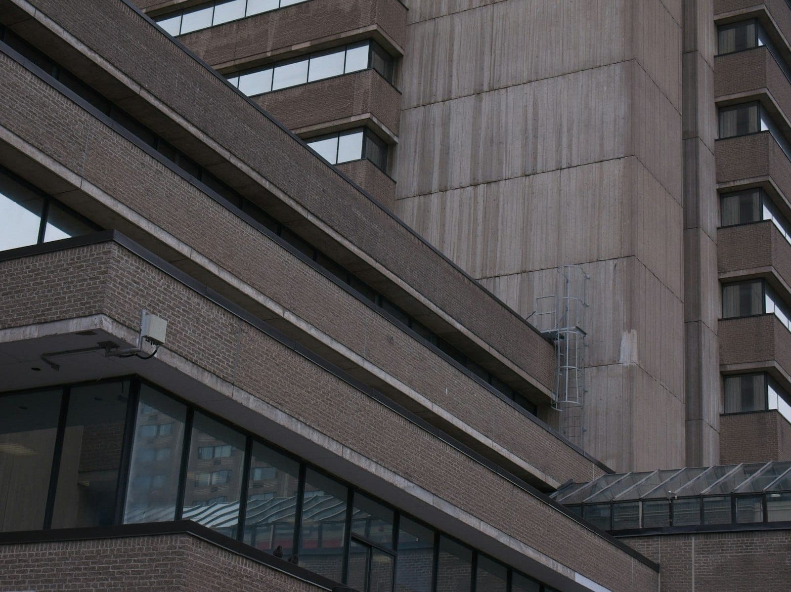Close-up view of a modern hospital or medical facility in Toronto, showing large windows and multi-story structure under natural light.