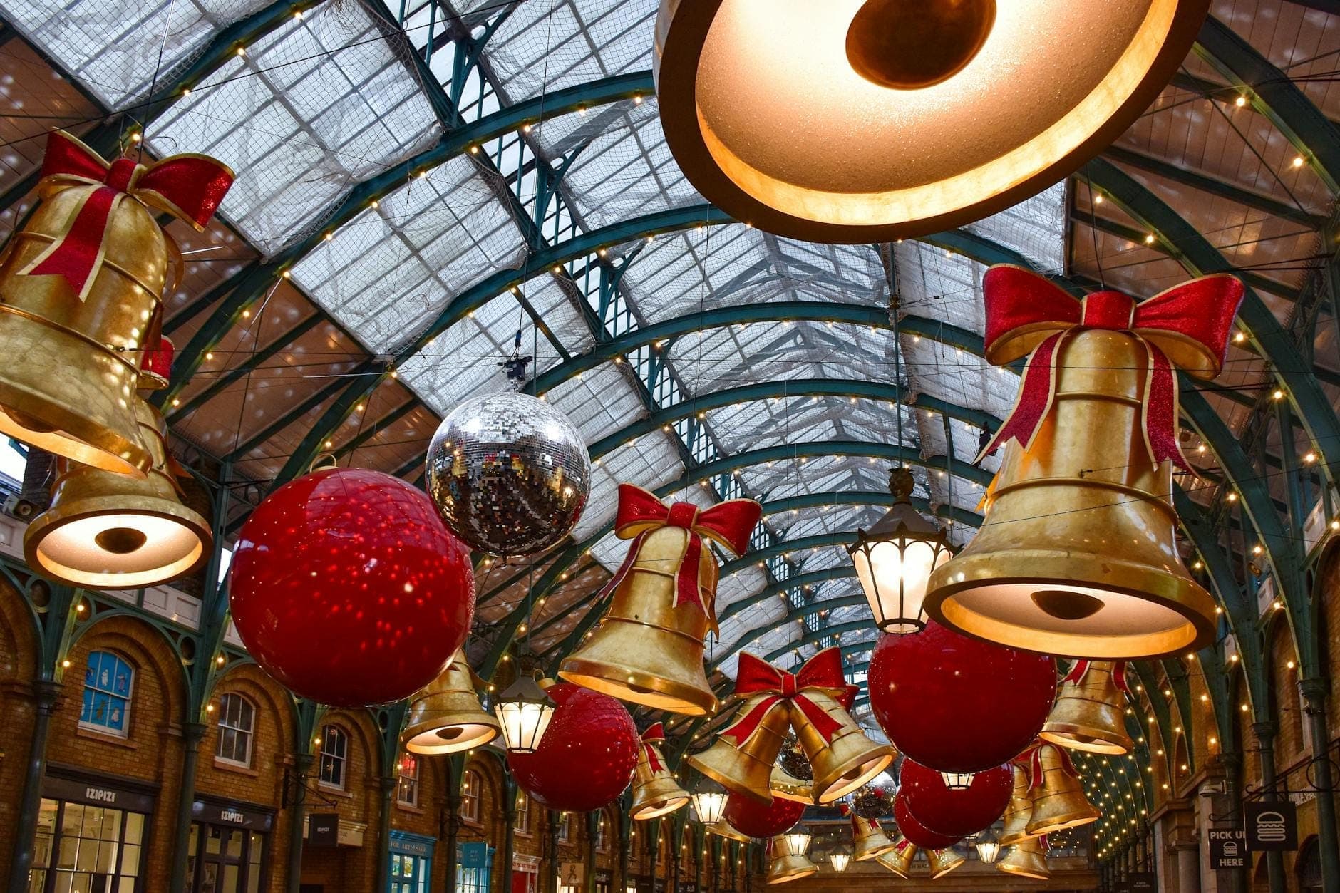 Covent Garden udekorowane gigantycznymi złotymi dzwonami, czerwonymi bombkami i migoczącymi świątecznymi lampkami pod szklanym dachem – świąteczny Londyn w grudniu.