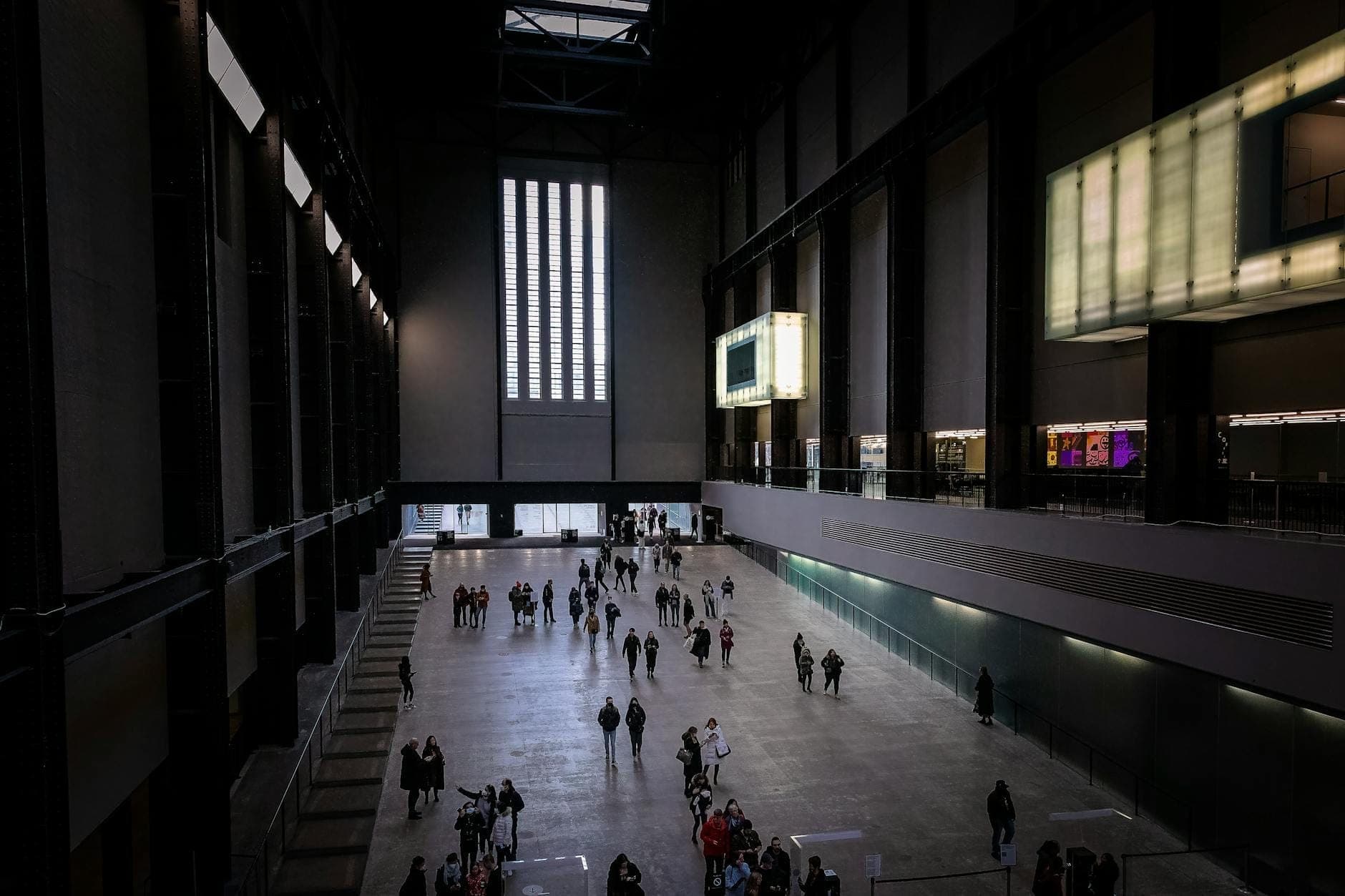 Szeroki widok na Turbine Hall w Tate Modern z odwiedzającymi spacerującymi i gromadzącymi się w ikonicznym londyńskim muzeum sztuki.