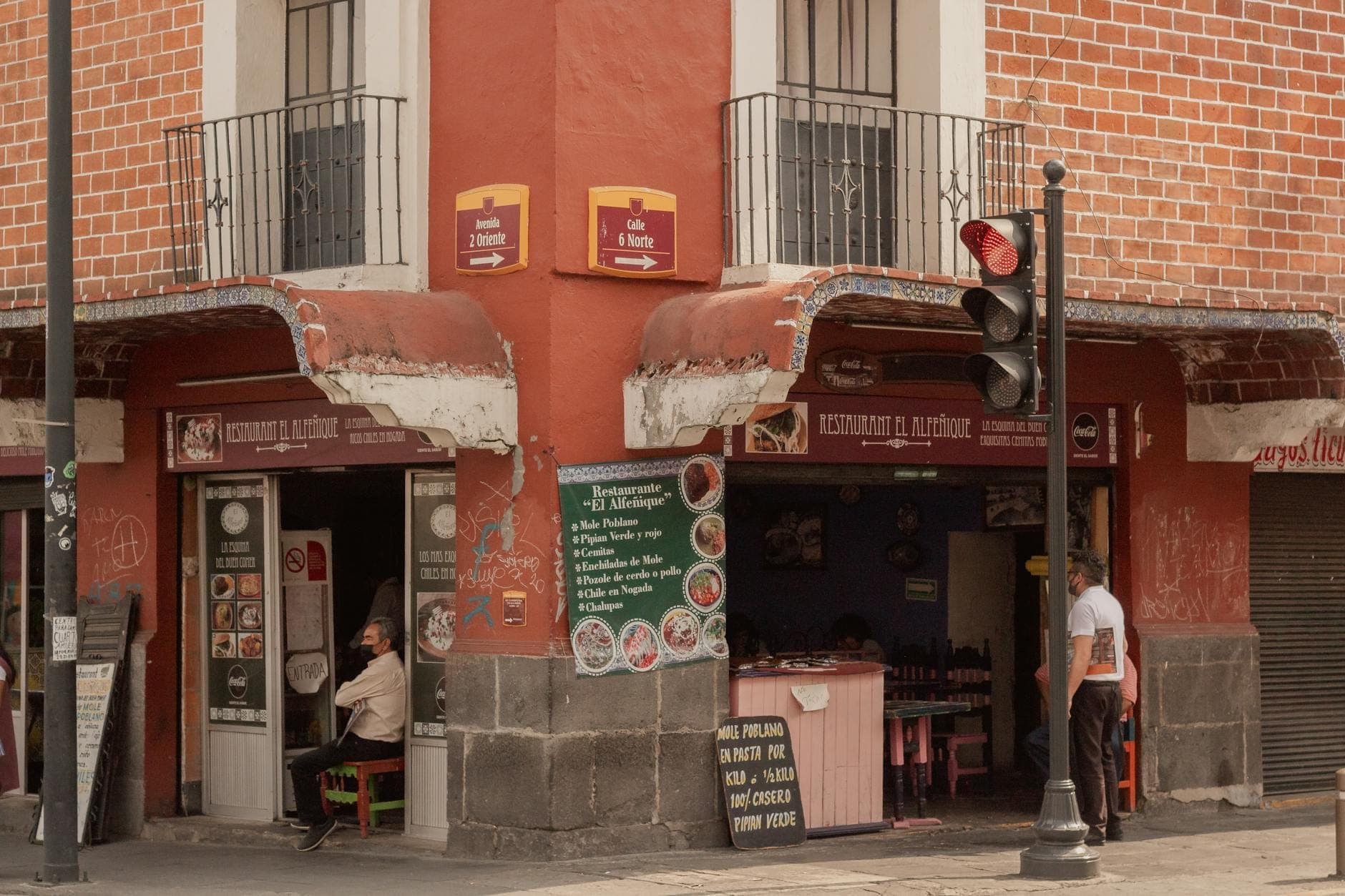 Persone sedute e in relax in un ristorante d'angolo ombreggiato a Mexico City durante il giorno.