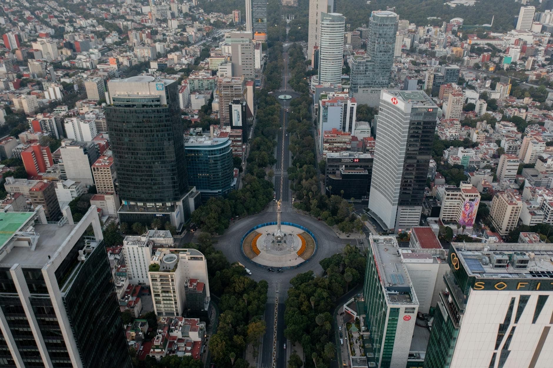 Vista aérea del Paseo de la Reforma en Ciudad de México, con hoteles de lujo y edificios de oficinas alrededor del monumento al Ángel de la Independencia.