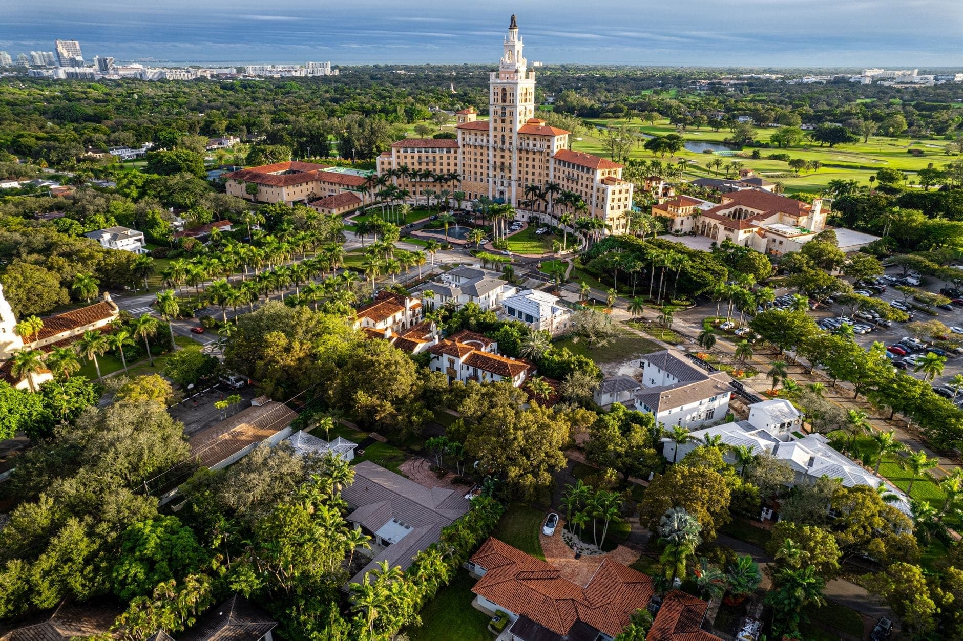 Aerial view of the historic Biltmore Hotel in Coral Gables, surrounded by lush greenery and historic buildings.