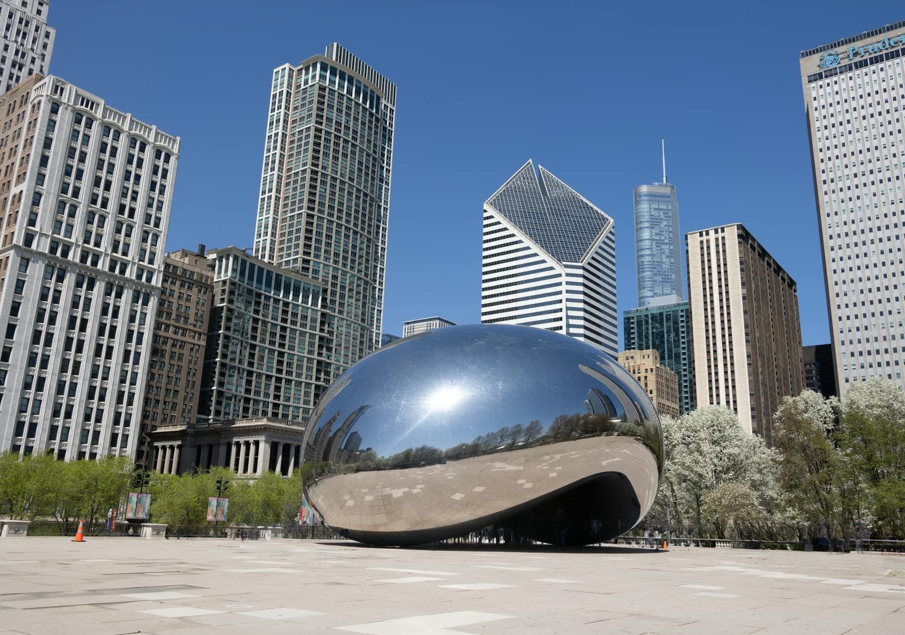 วิวกว้าง Millennium Park กับประติมากรรม Cloud Gate ล้อมรอบด้วยตึกสูงกลางเมืองชิคาโก ในวันที่แดดใสท้องฟ้าเปิด
