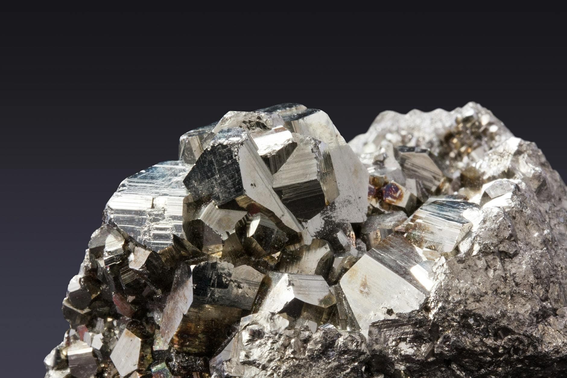 Primer plano de una muestra mineral metálica con cristales brillantes y angulares en exhibición en el Museo dell'Arte Mineraria en Iglesias.