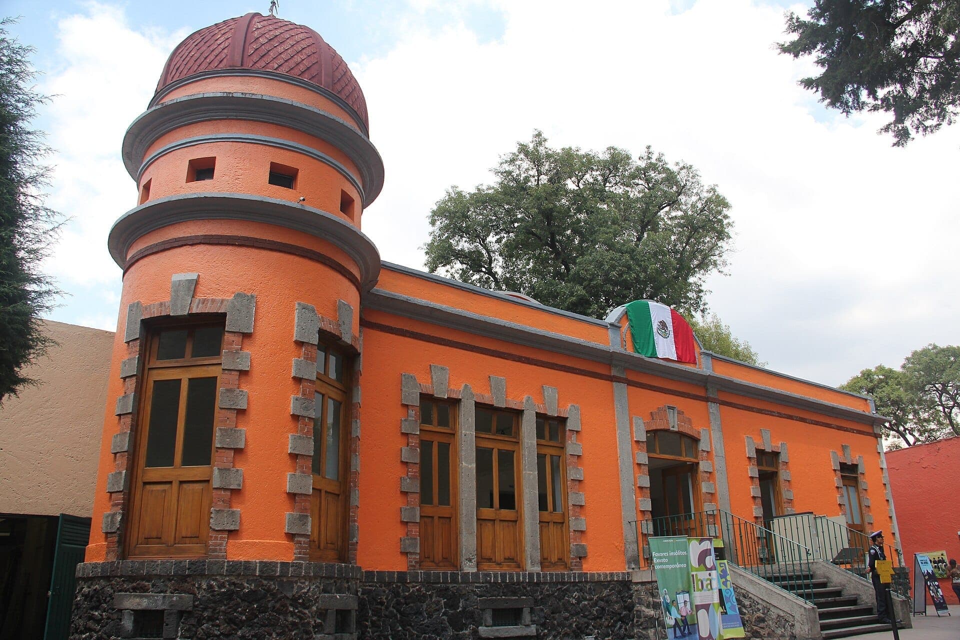 อาคารสีส้มสดใสพร้อมลวดลายหินและหอคอยทรงกลม ที่ตั้งของ Museo Nacional de Culturas Populares ใน Coyoacán เมกซิโกซิตี้