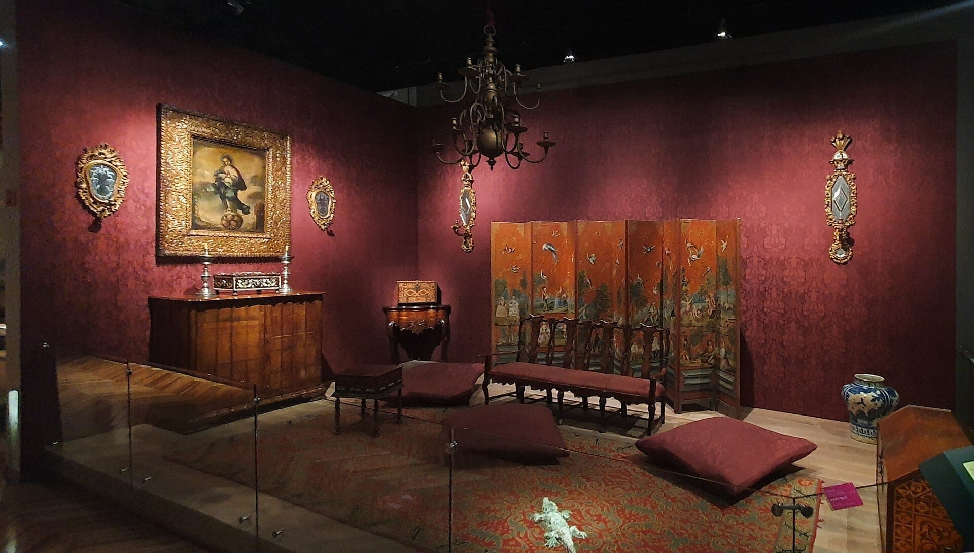 นิทรรศการในหอศิลป์ที่ Museo Franz Mayer จัดแสดงเฟอร์นิเจอร์ยุคอาณานิคมสวยงาม ภาพศิลปะทางศาสนากรอบทอง ฉากพับตกแต่ง และเบาะนุ่มในห้องที่มีแสงไฟอบอุ่น
