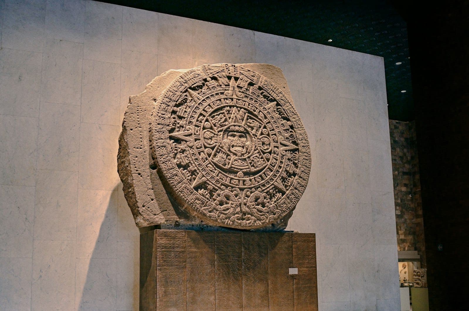 หินดวงอาทิตย์แอซเท็กที่จัดแสดงอยู่ใน Museo Nacional de Antropología โดยมีฉากหลังเป็นกำแพงหินสีกลางที่ได้รับแสงสว่างอ่อนๆ ภายในพิพิธภัณฑ์