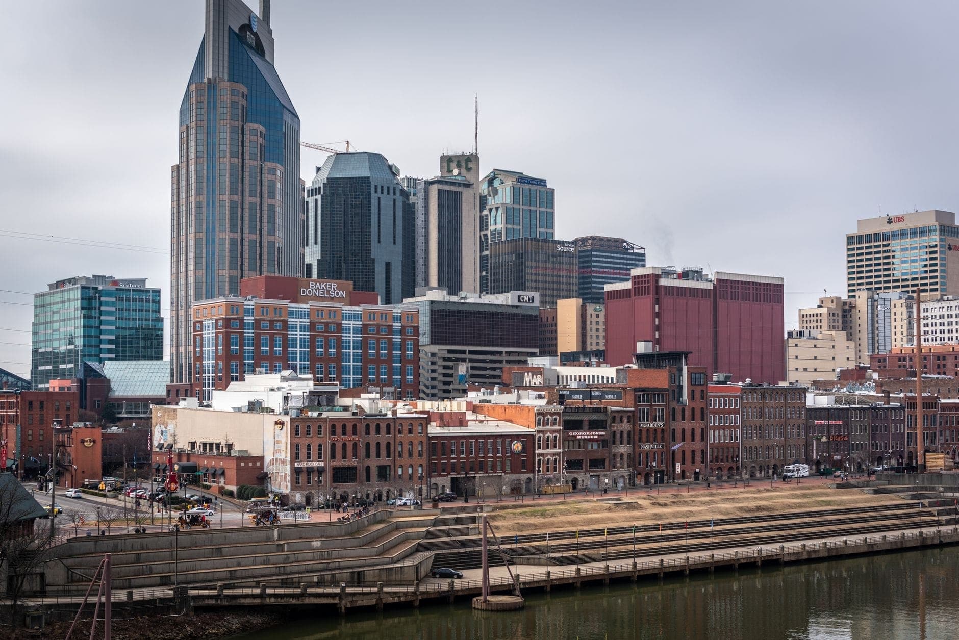 Horizonte do centro de Nashville com históricos edifícios de tijolo ao longo da orla do rio e o icónico AT&T Building à vista.