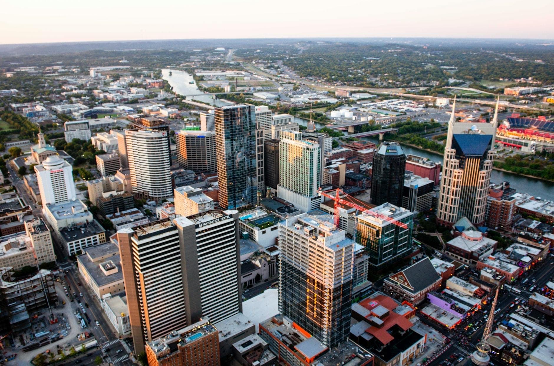 Widok z lotu ptaka na panoramę centrum Nashville z wieżowcami, hotelami i rzeką, ukazujący najlepsze dzielnice dla luksusowych podróżnych.
