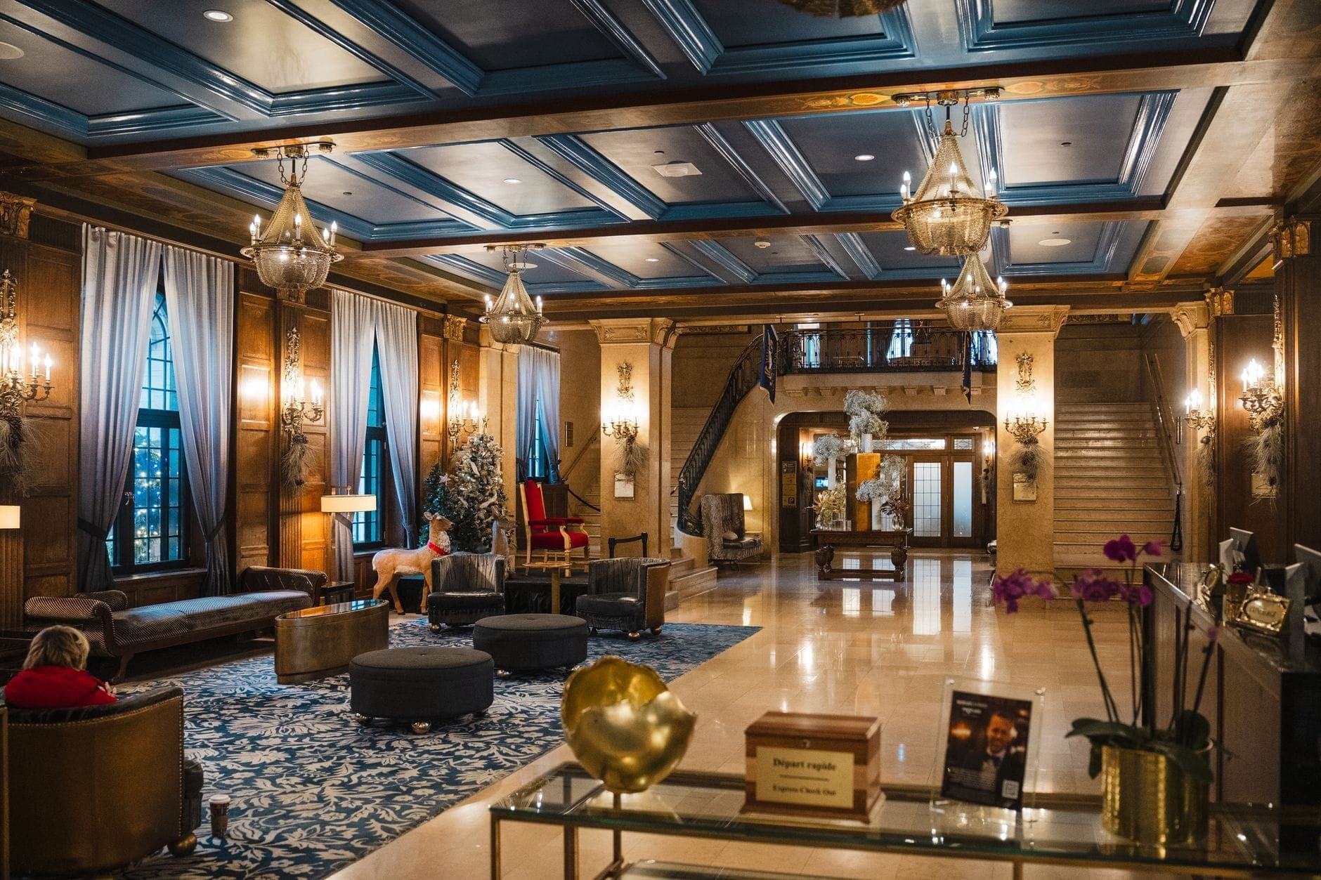 Luksusowy hol hotelowy z eleganckimi żyrandolami, niebieskim sufitem, zdobnymi detalami drewnianymi, wygodnymi siedzeniami i okazałą, gościnną klatką schodową w Nashville.
