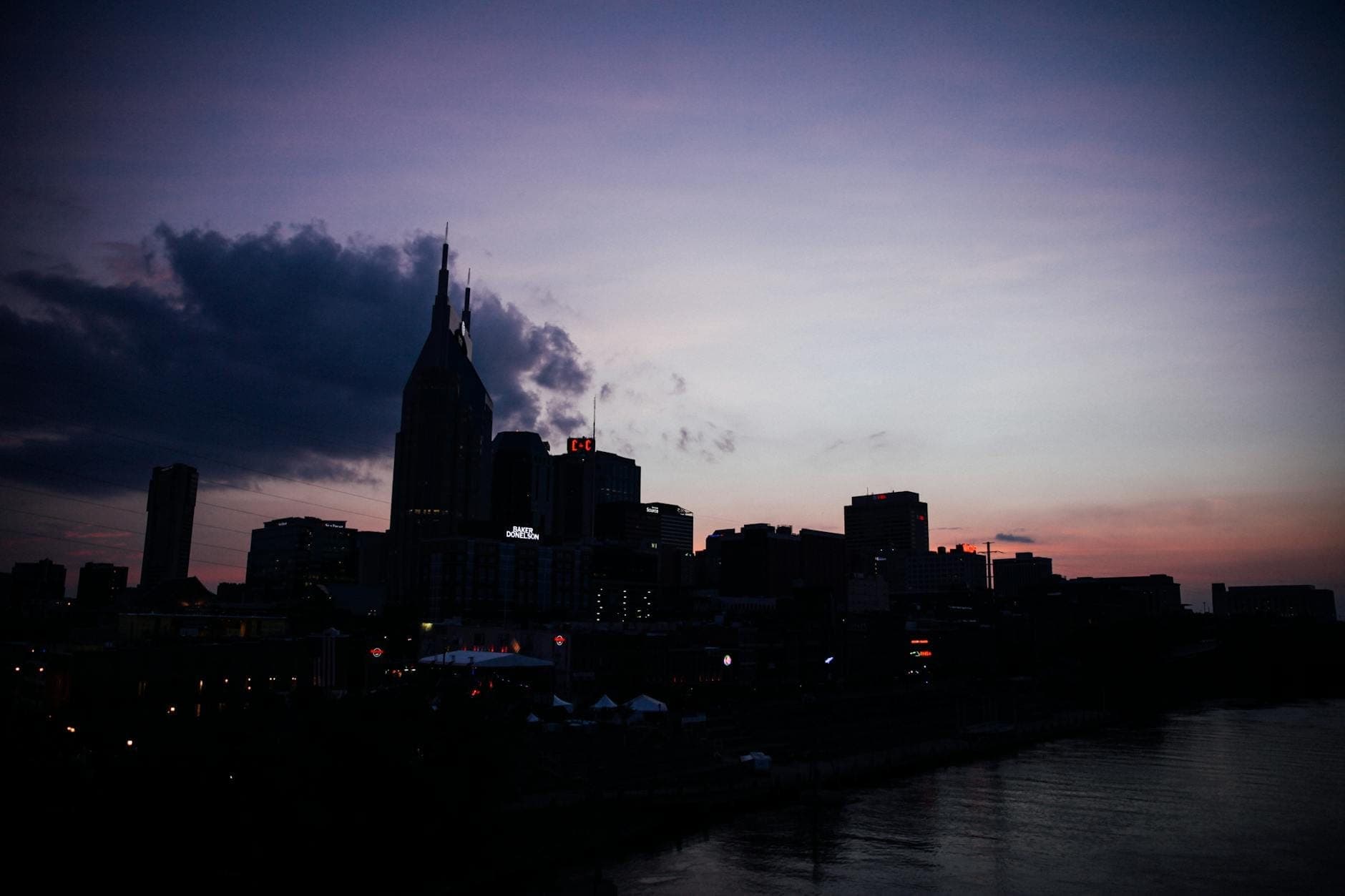 Horizonte de Nashville al atardecer con los reconocibles edificios del centro y el río en primer plano.