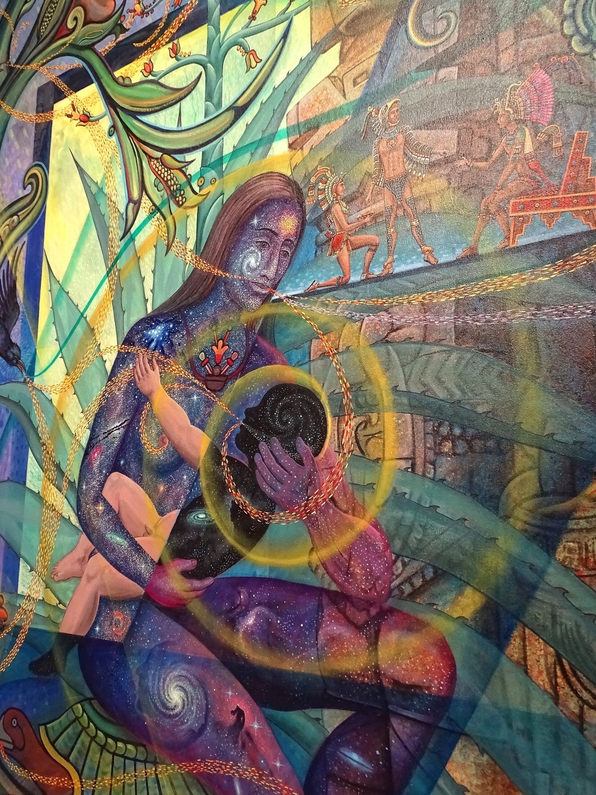 Colorful mural at the National Museum of Mexican Art featuring mythological figures, Aztec imagery, and cosmic designs in vivid blue and gold tones.