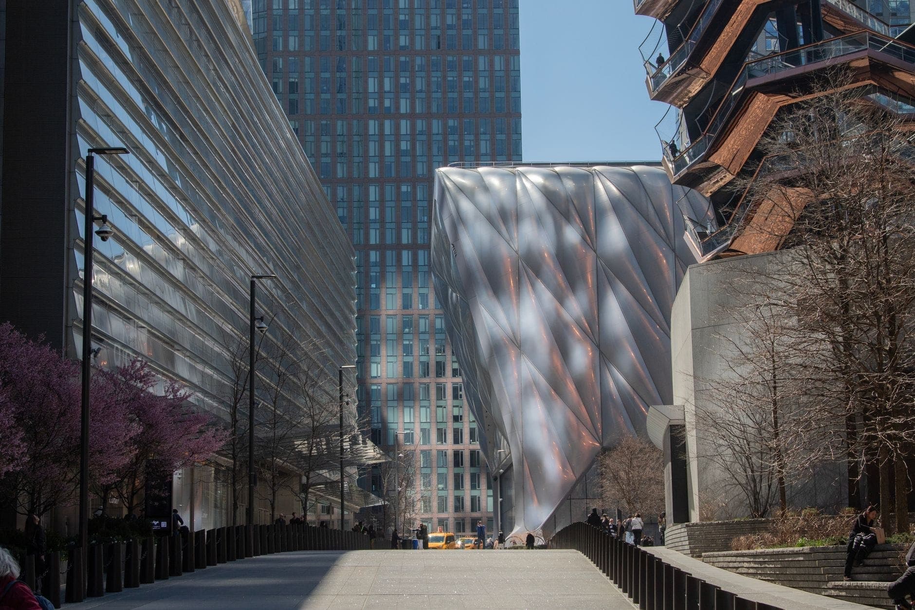 อาคารสีเงินทันสมัยของศูนย์ศิลปะ The Shed ใน Hudson Yards ล้อมรอบด้วยตึกระฟ้าและ The Vessel ในนิวยอร์กซิตี้
