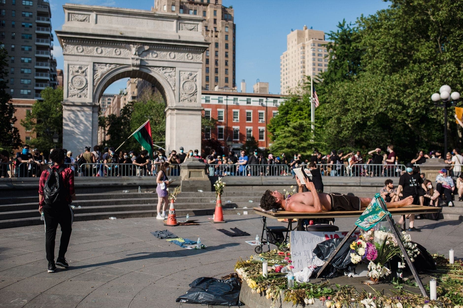 ผู้คนมารวมตัวและพักผ่อนใน Washington Square Park โดยมีประตูโค้งอันโด่งดังเป็นฉากหลังในวันที่แดดสดใสที่ New York City