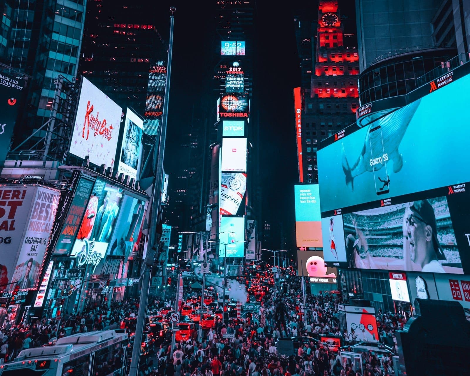 Times Square ที่คึกคักในยามค่ำคืนพร้อมป้ายโฆษณาสว่างไสวและอาคาร One Times Square สถานที่จัดงาน Ball Drop คืนส่งท้ายปีเก่า