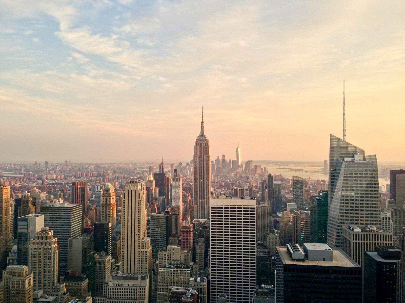 วิวสูงของเส้นขอบฟ้า Midtown Manhattan ยามพระอาทิตย์ตก พร้อม Empire State Building และตึกระฟ้าใต้ท้องฟ้าหลากสี