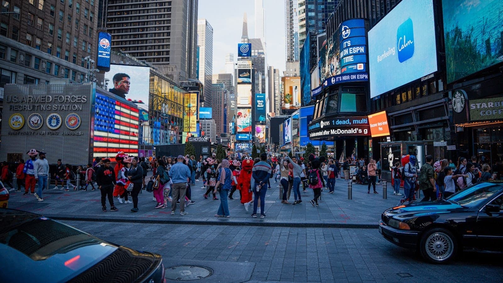 Times Square ที่เต็มไปด้วยฝูงชน นักแสดงสวมชุดแฟนซี และป้ายโฆษณาหลากสีสัน ซึ่งบ่งบอกถึงพื้นที่ที่คึกคักที่อาจเกิดการหลอกลวงนักท่องเที่ยวทั่วไปในนิวยอร์กได้
