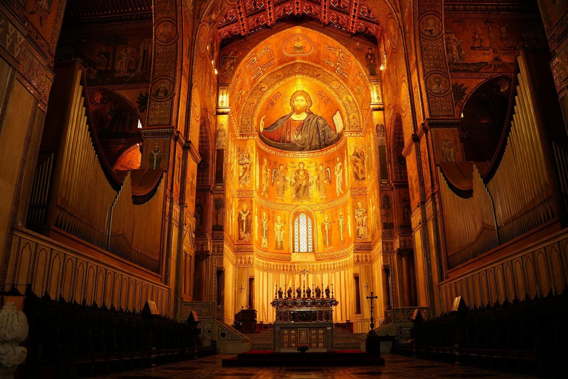 Malawak na tingin ng mga ornamentadong gintong mosaic at altar sa loob ng isang maringal na Byzantine-Norman na simbahan sa Palermo, Sicily.
