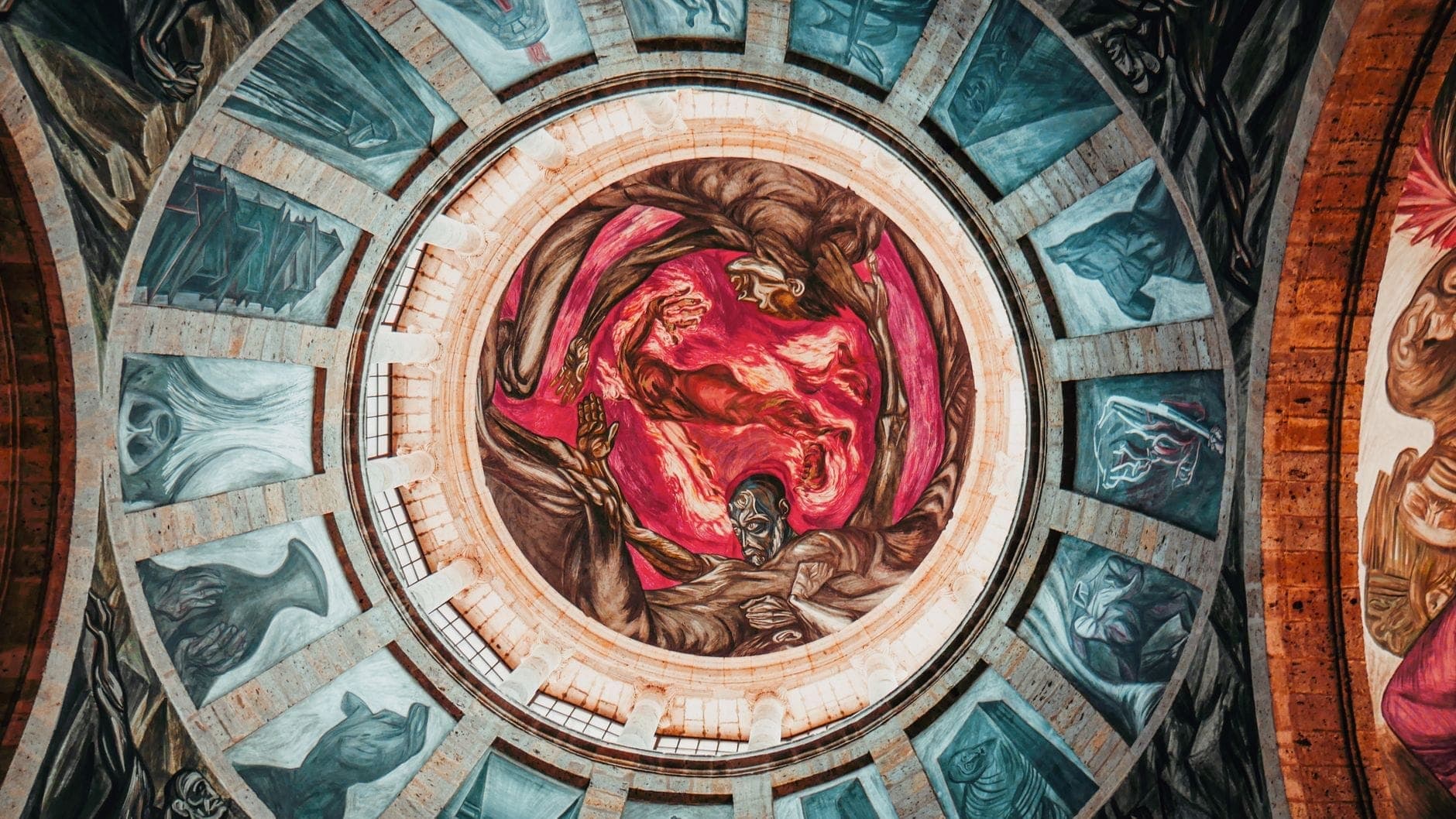 มองขึ้นไปยังโดมของ Hospicio Cabañas ในกวาดาลาฮาราที่ปกคลุมด้วยภาพจิตรกรรมฝาผนังอันน่าตื่นตาของ José Clemente Orozco พร้อมสีสันเข้มข้นและรูปบุคคลขนาดใหญ่โต