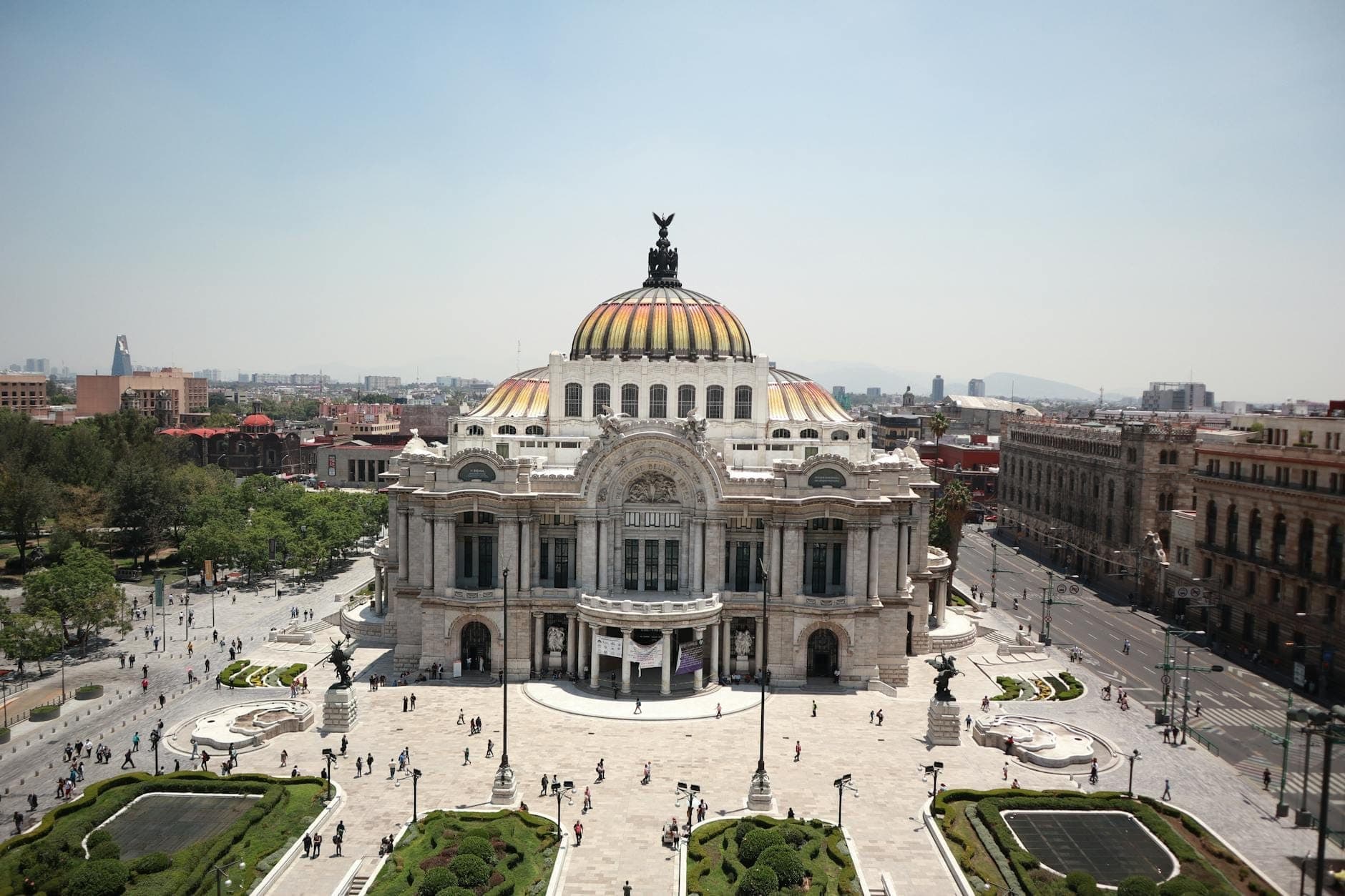 มุมกว้างของ Palacio de Bellas Artes หมวกโดมหินอ่อนอันเป็นเอกลักษณ์ ท่ามกลางสวนและนักท่องเที่ยวมากมายในเม็กซิโกซิตี้