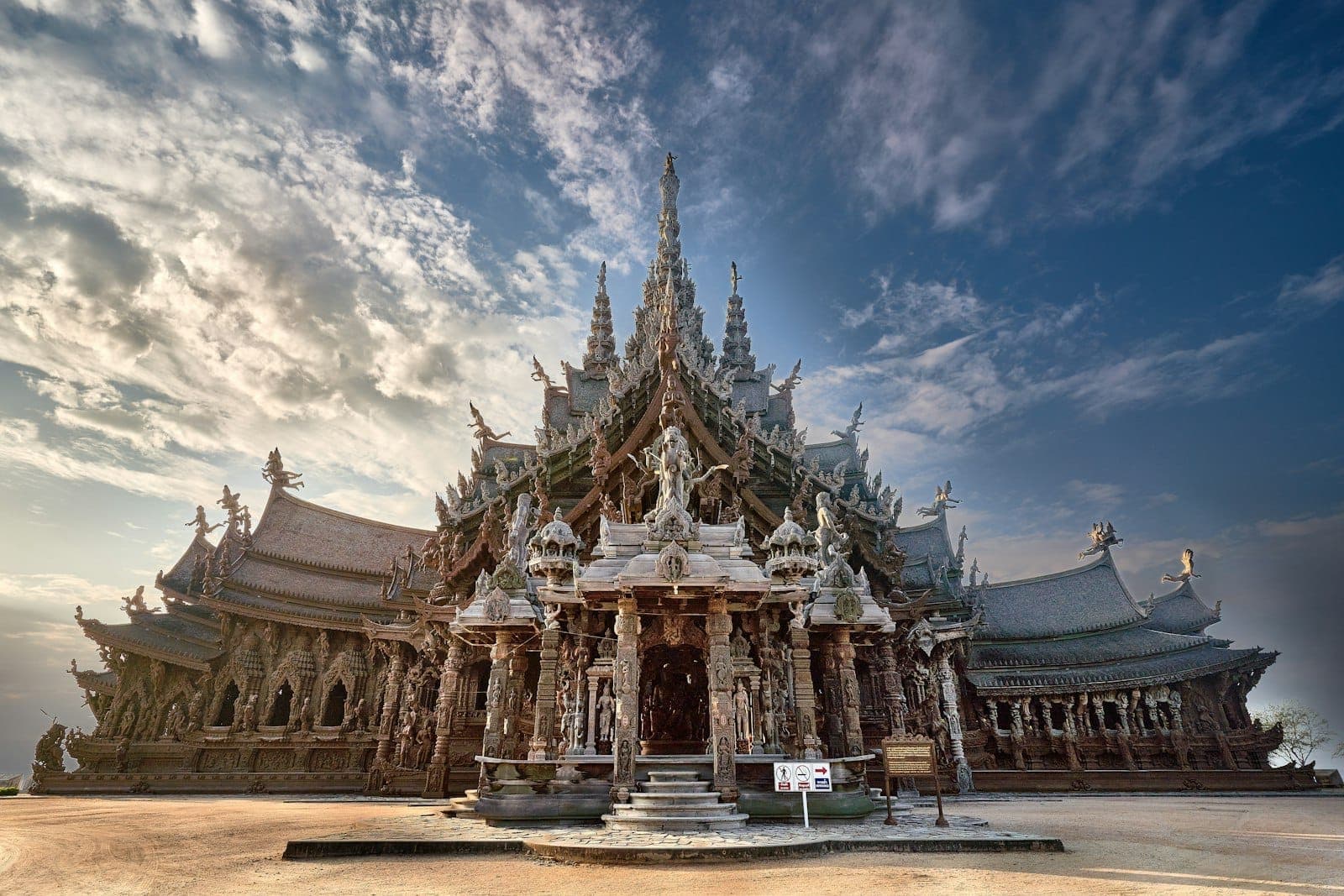 วิวกว้างของ Sanctuary of Truth วิหารไม้แกะสลักอย่างวิจิตรขนาดใหญ่โตพร้อมยอดแหลมที่โดดเด่นใต้ท้องฟ้าที่มีเมฆบางส่วน