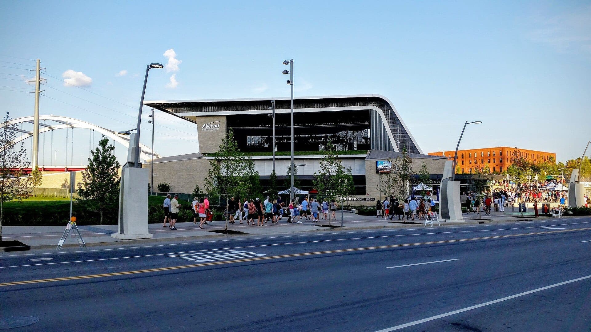 View of Ascend Amphitheater at Riverfront Park in Nashville, with crowds gathering outside and the iconic bridge in the background.
