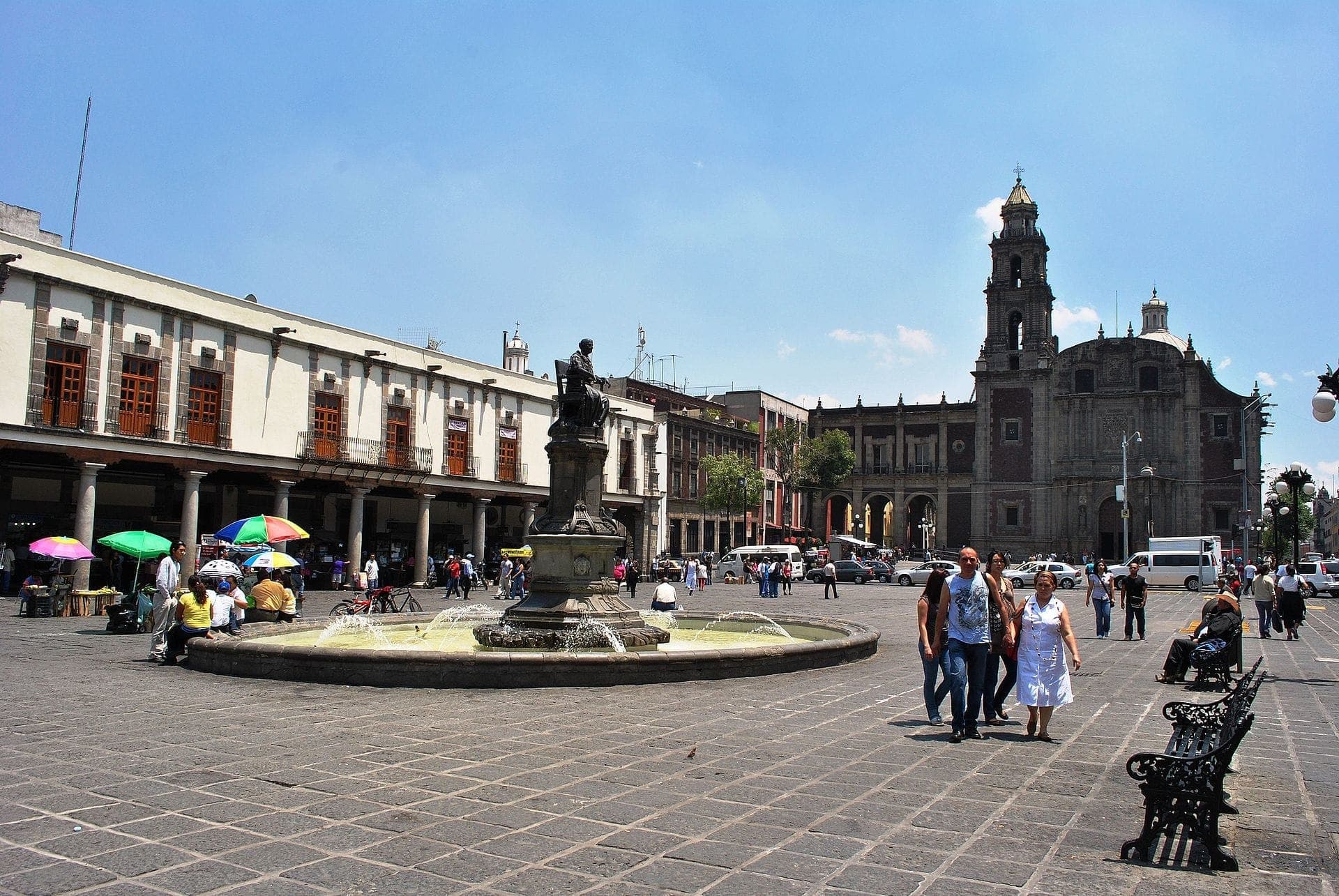 Plaza de Santo Domingo มีน้ำพุกลางจัตุรัส อาคารอาณานิคมทางประวัติศาสตร์ โบสถ์บาโรก และผู้คนที่เพลิดเพลินกับจัตุรัสสาธารณะที่คึกคัก