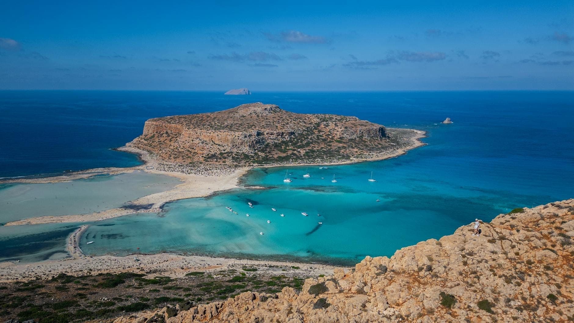 Atemberaubende Luftaufnahme der Balos-Lagune mit türkisfarbenem Wasser, Sandstrand und zerklüfteter Küste vor strahlend blauem Himmel auf Kreta, Griechenland.