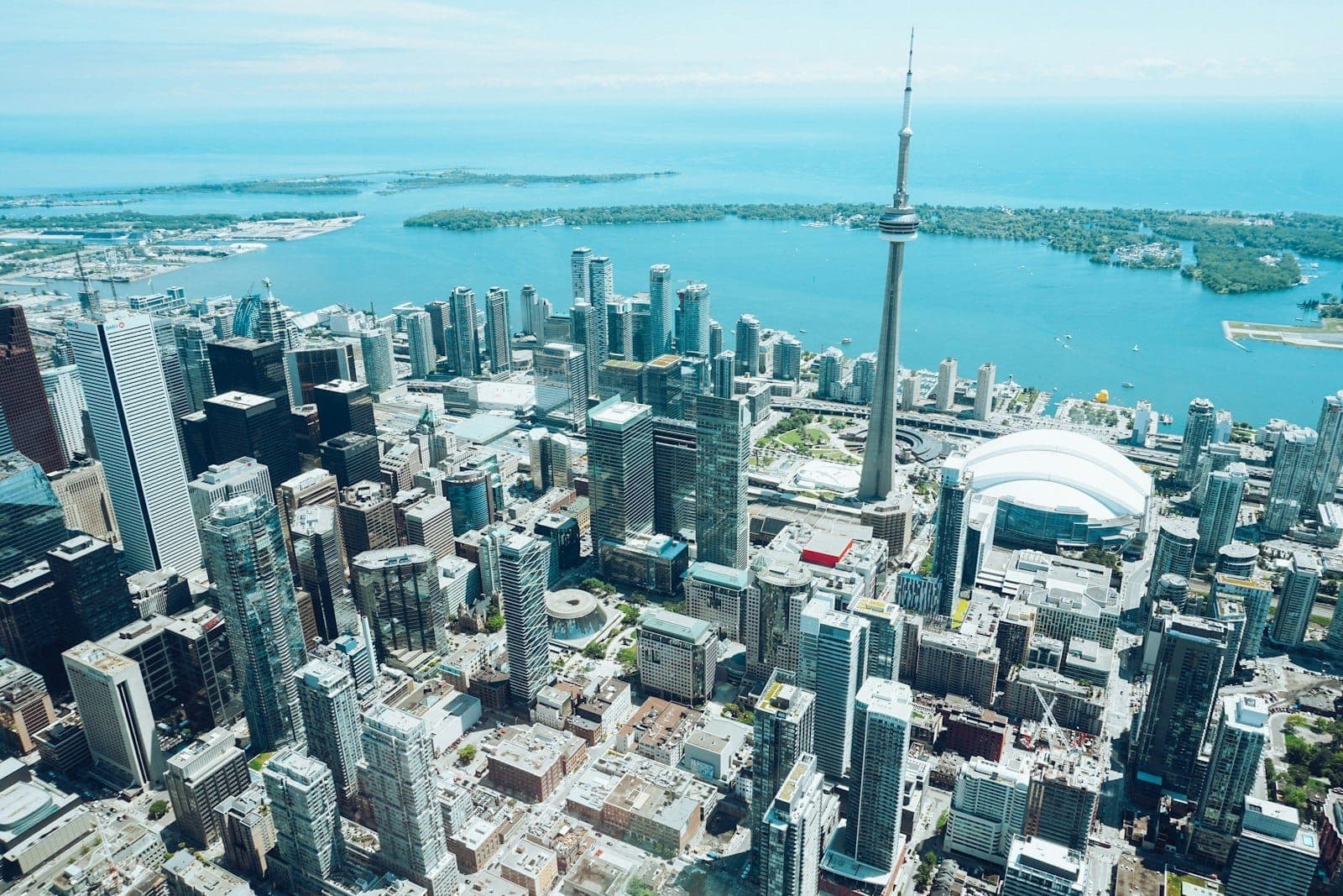 Aerial view of downtown Toronto with the CN Tower and Rogers Centre by the waterfront on a clear day.