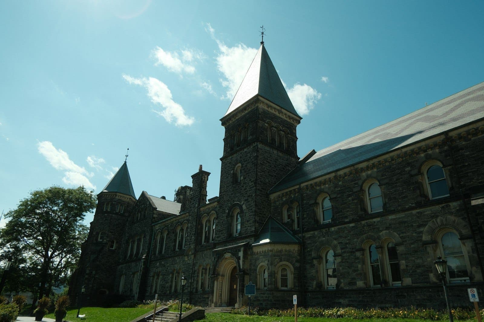 Gothic-style stone building with towers under a blue sky, showcasing the historic architecture of a Toronto museum or university.