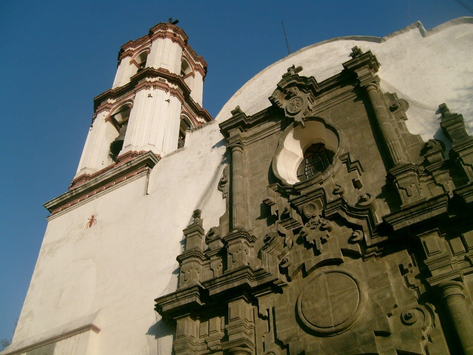 รายละเอียดหน้าบันและหอระฆังสไตล์บาโรกของโบสถ์ Kiosco Morisco ในย่าน Santa María la Ribera ใต้ท้องฟ้าสีครามสดใส