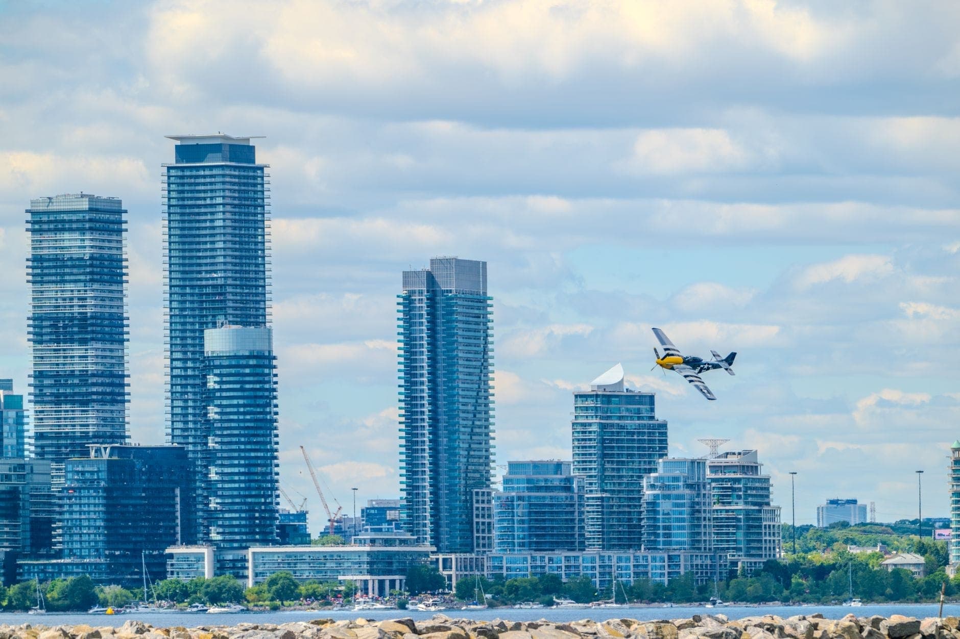 Un piccolo aereo commerciale in decollo davanti allo skyline di Toronto, che rappresenta la posizione del Billy Bishop Toronto City Airport.