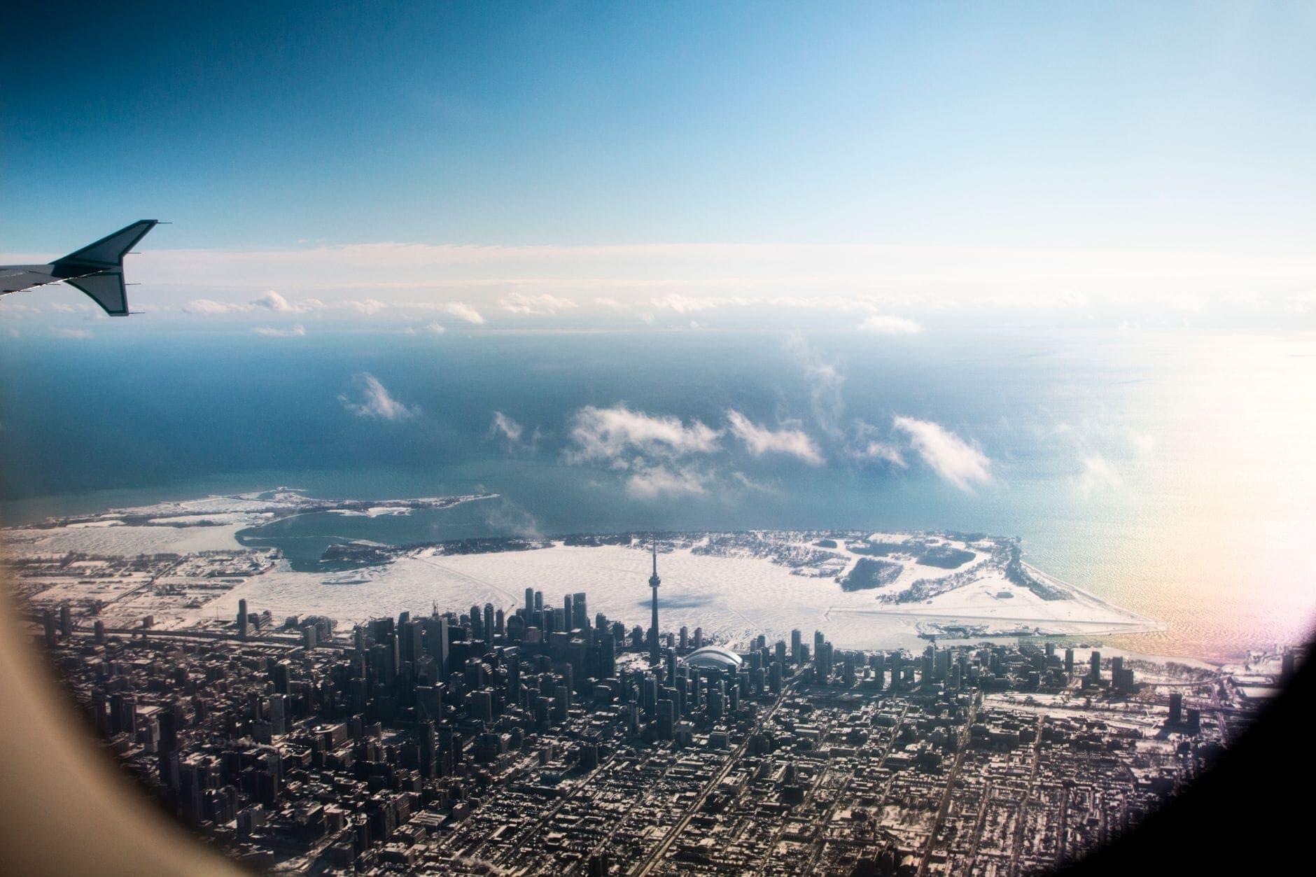 Aerial view of Toronto Islands and downtown skyline taken from an airplane window, showing the islands’ shape and lake setting.