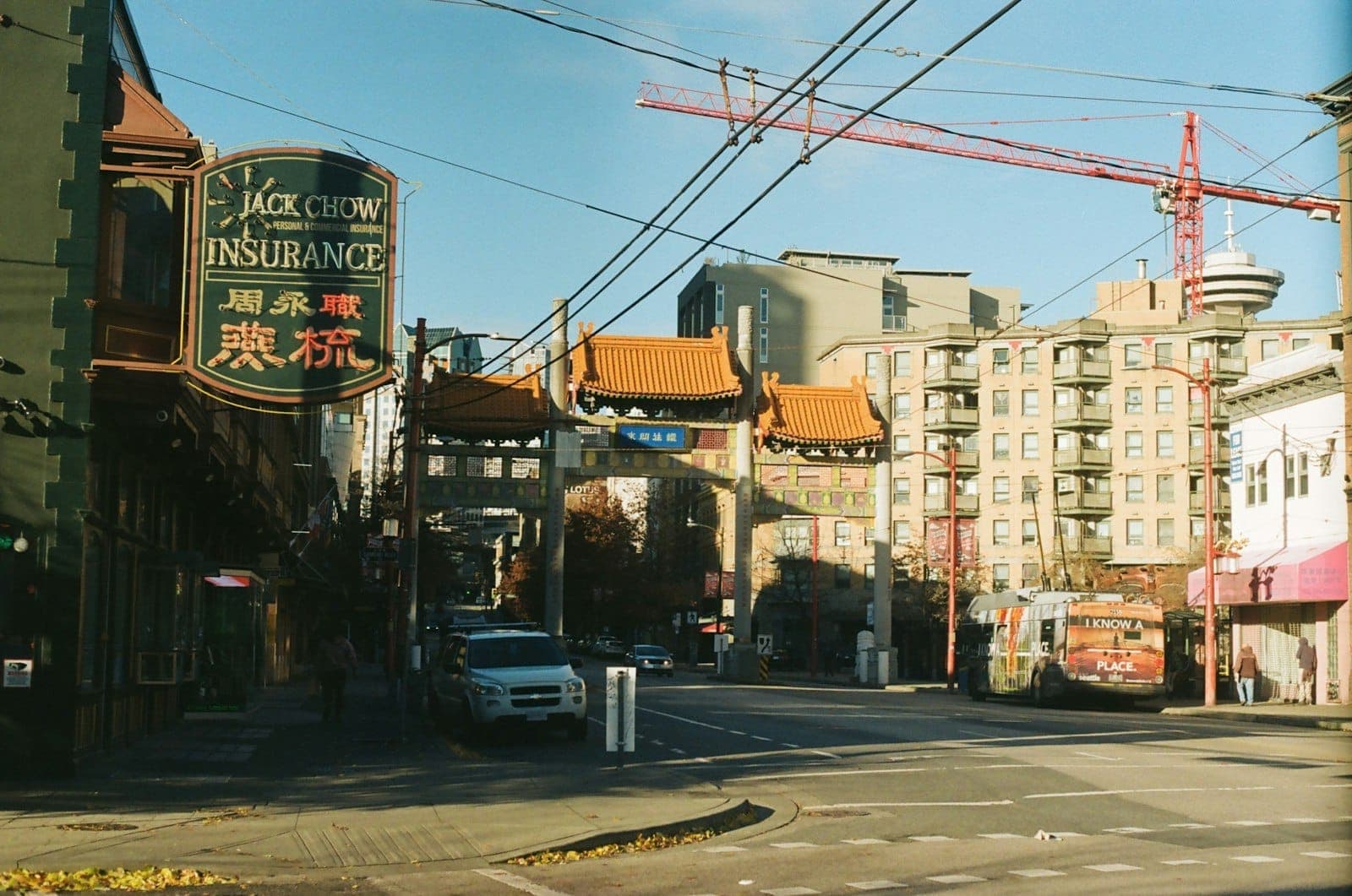 Chinatown Millennium Gate ในเมือง Vancouver ในวันที่แดดสดใส โดยมีร้านค้าใกล้เคียงและอาคารในเมืองให้เห็น