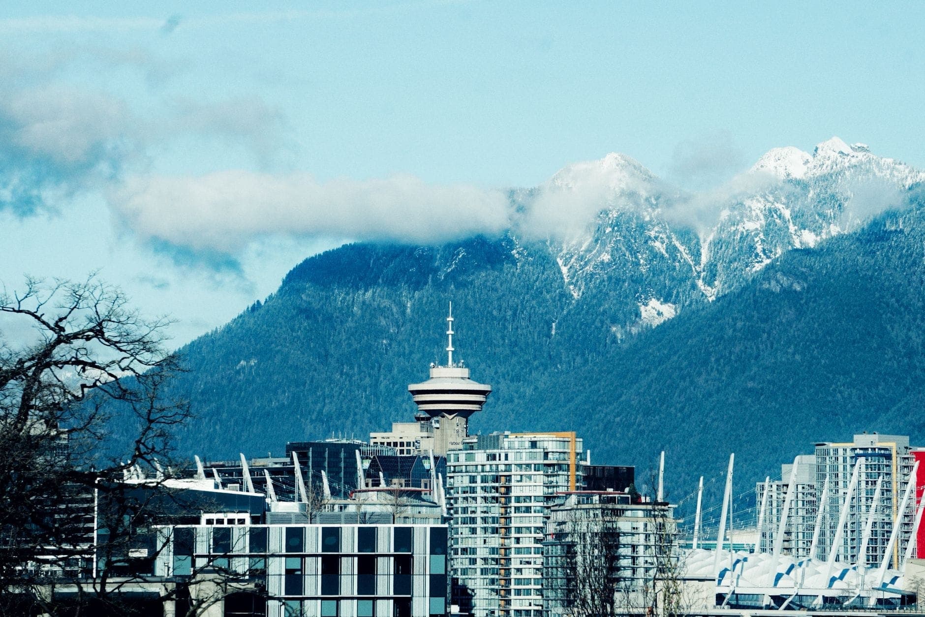 Vancouver Lookout ที่ Harbour Centre สูงตระหง่านเหนืออาคารใจกลางเมืองโดยมีเทือกเขา North Shore และเมฆต่ำเป็นฉากหลัง