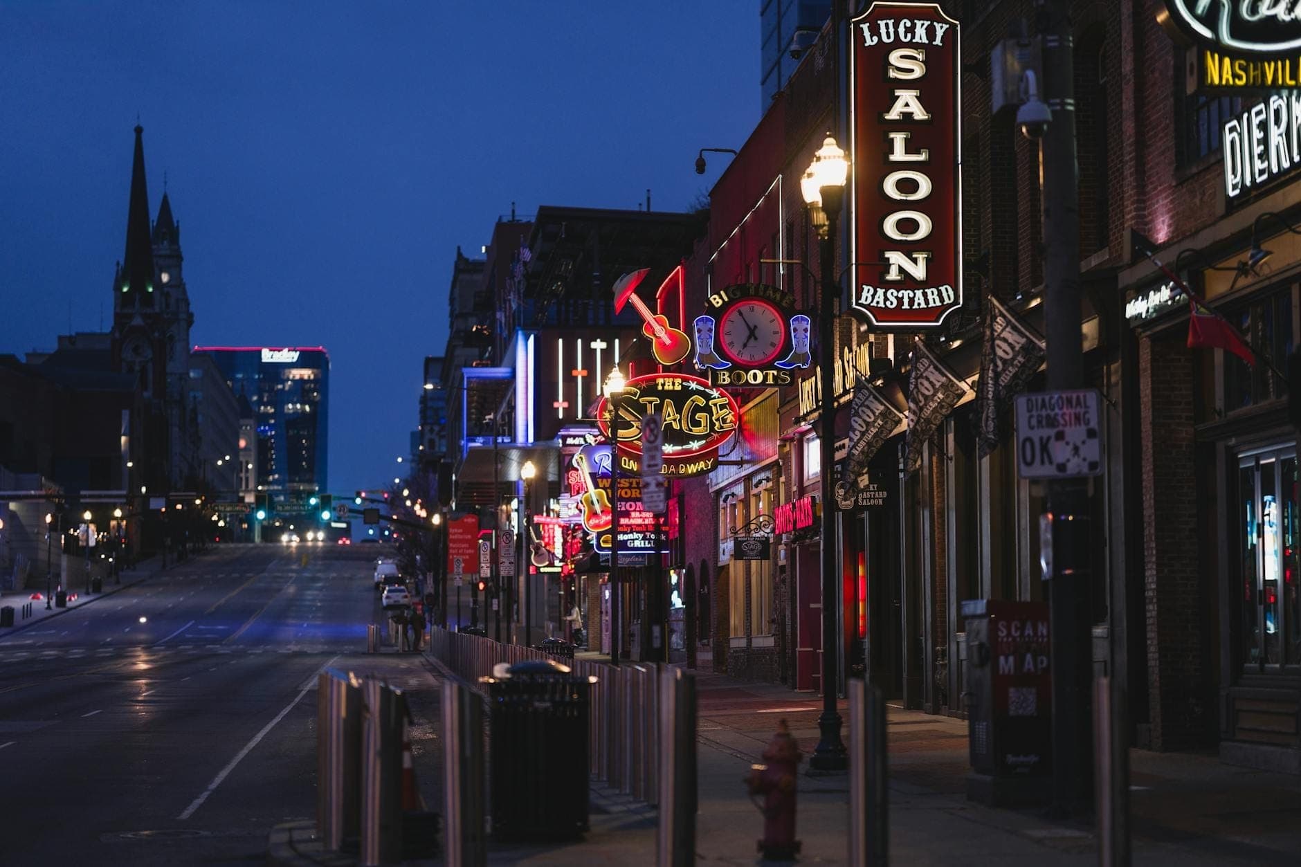 Animada escena nocturna en el centro de Nashville, con letreros de neón de restaurantes y bares, capturando el distrito de entretenimiento de Broadway.