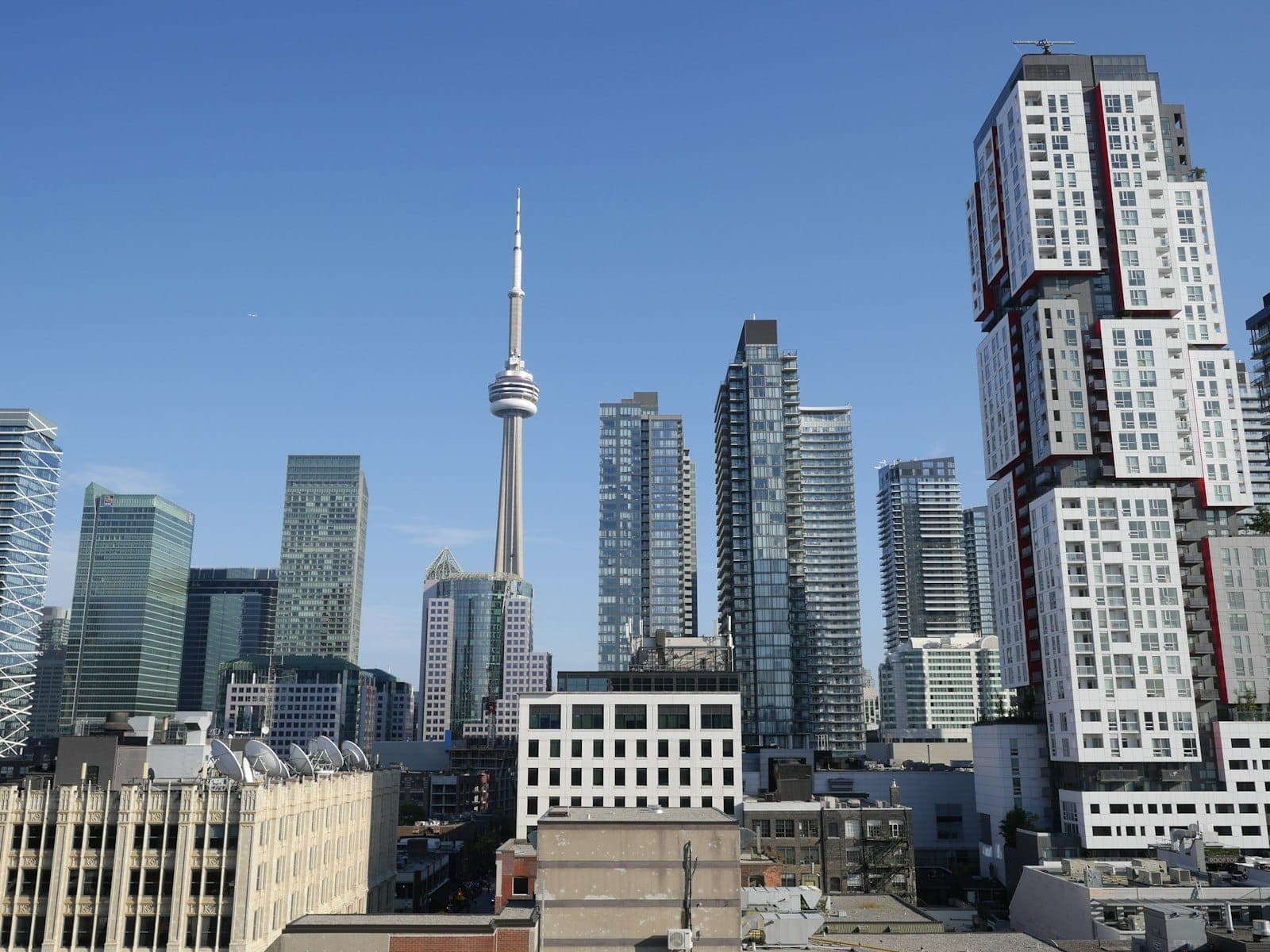 Downtown Toronto skyline with the CN Tower and modern high-rise buildings on a clear sunny day.