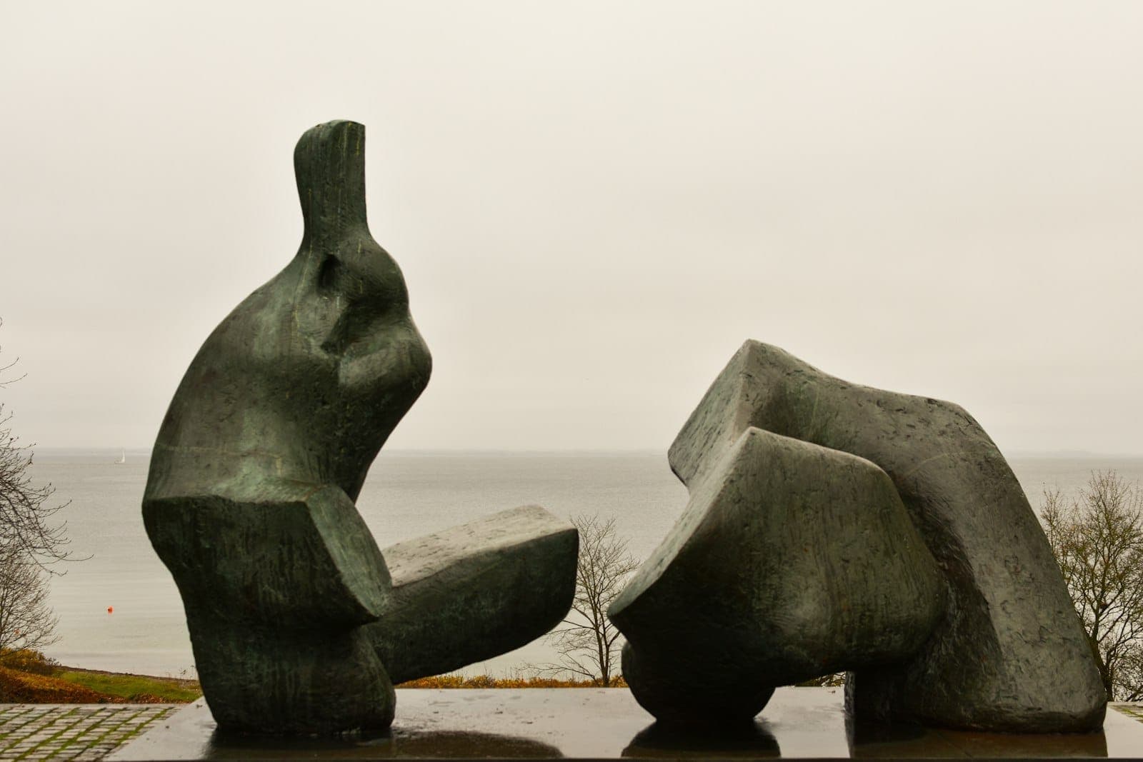 Escultura abstrata ao ar livre com o mar ao fundo num dia nublado