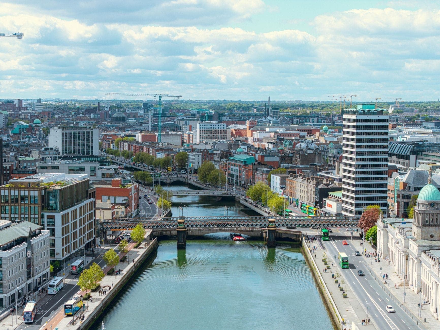 Eine klare, helle Luftaufnahme der Innenstadt von Dublin mit dem River Liffey, Brücken und vielen markanten Stadtgebäuden.