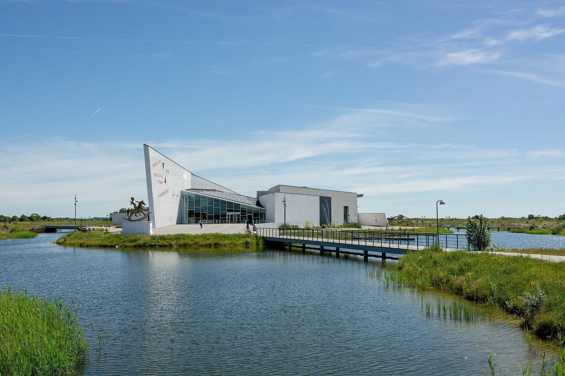 Il ARKEN Museum of Modern Art si trova sulla costa di Ishøj, con la sua caratteristica architettura bianca angolare, l'acqua che circonda l'edificio e un cielo azzurro limpido.
