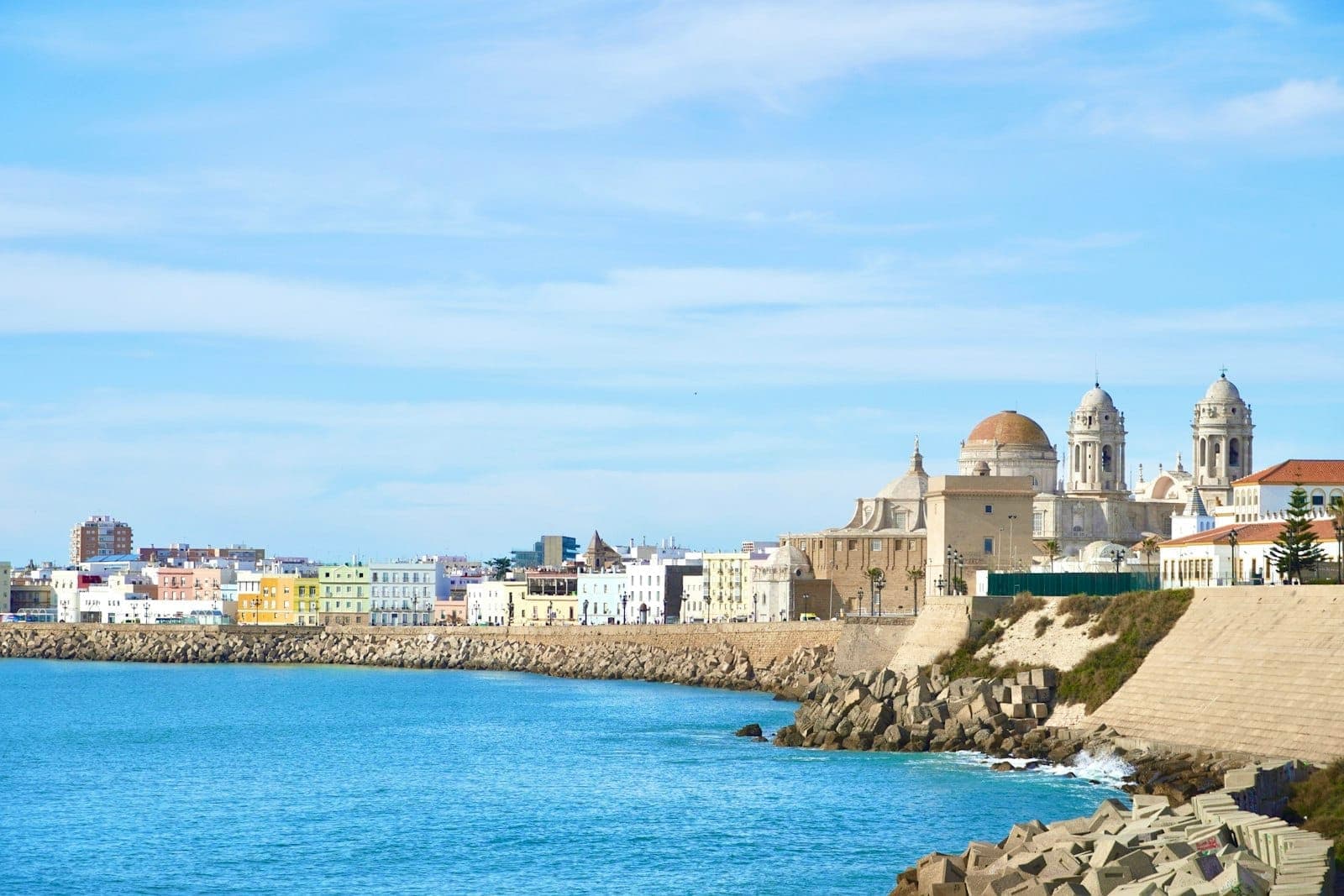 Tanawing panoramic ng lumang bayan ng Cádiz, kitang-kita ang Cathedral at mga sinaunang pader sa tabi ng dagat na bughaw sa ilalim ng maliwanag na langit.