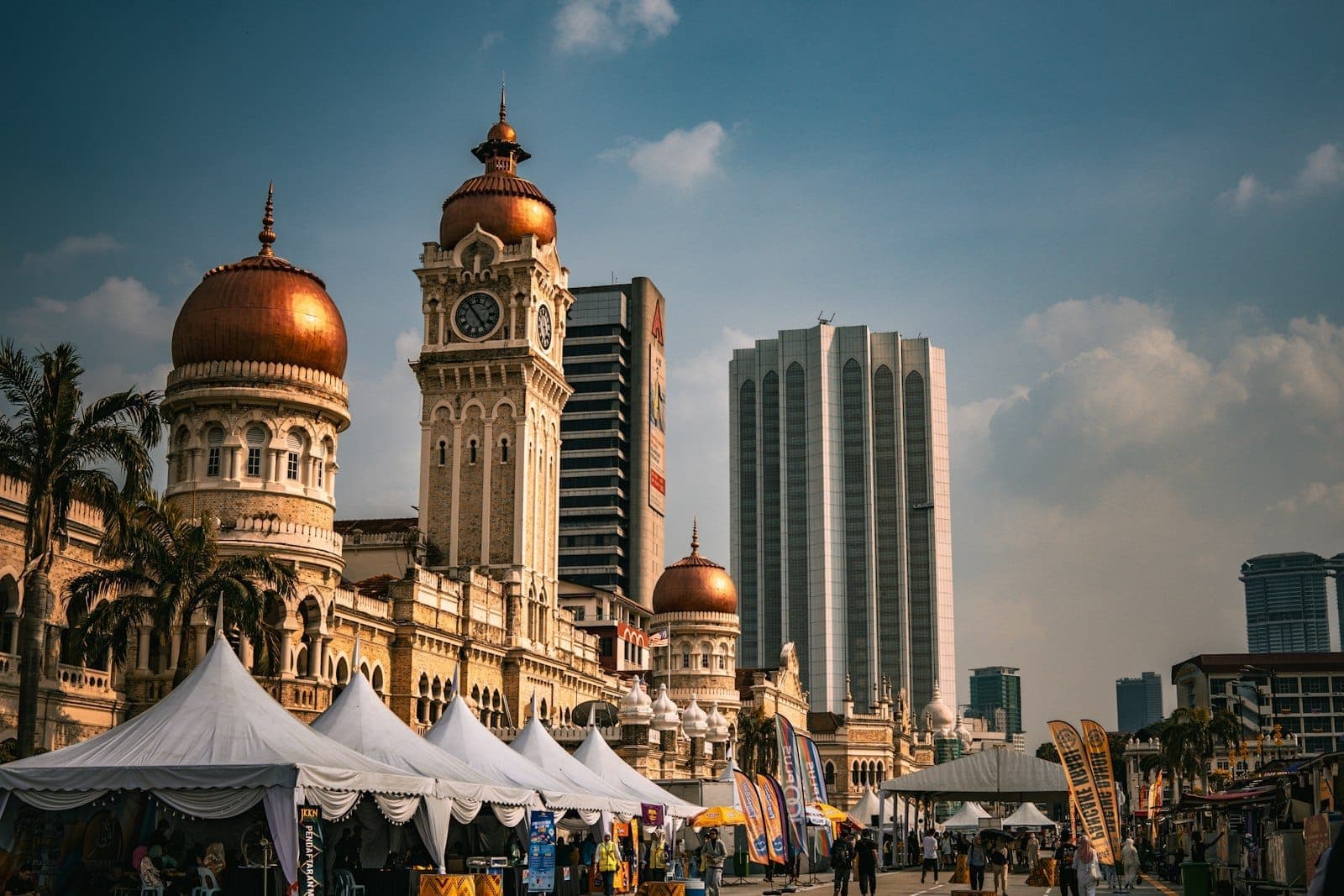 Toàn cảnh đường chân trời Kuala Lumpur từ tháp KL vào giờ vàng, với các tòa tháp biểu tượng và không gian đô thị rộng lớn.