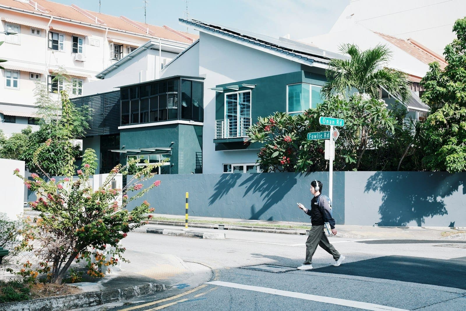 Modern houses and tropical greenery line the intersection of Onan Road and Fowlie Road in a sunny Singapore neighborhood.